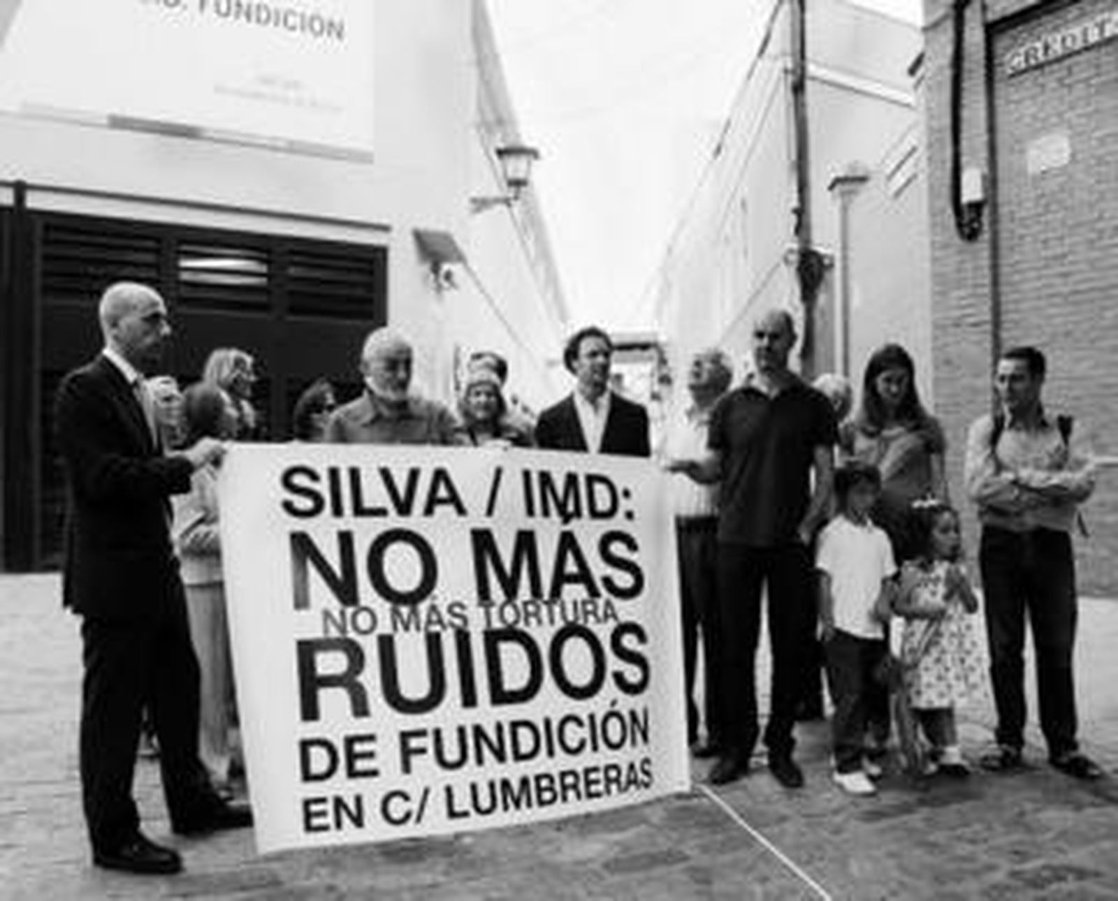 Los afectados por los ruidos de la piscina, junto a dos ediles del PP, desplegaron ayer una pancarta.