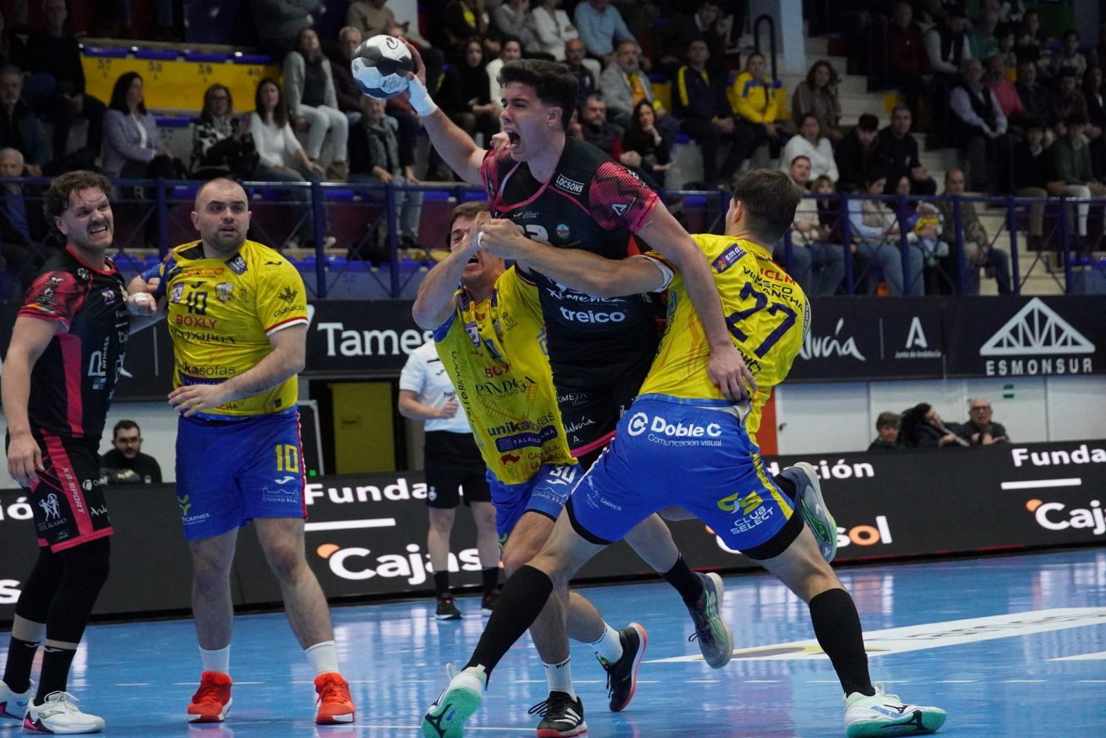 Serrano intenta zafarse de dos defensores del Caserío.