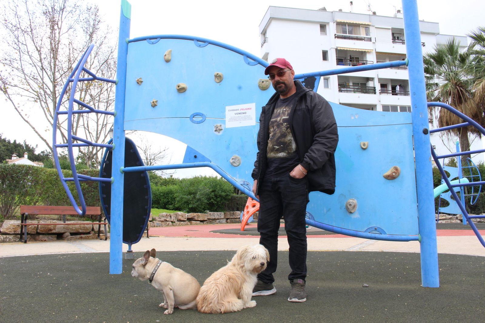 Moisés Rivera posa junto a sus perras en un parque infantil donde alertan de envenenamiento de mascotas