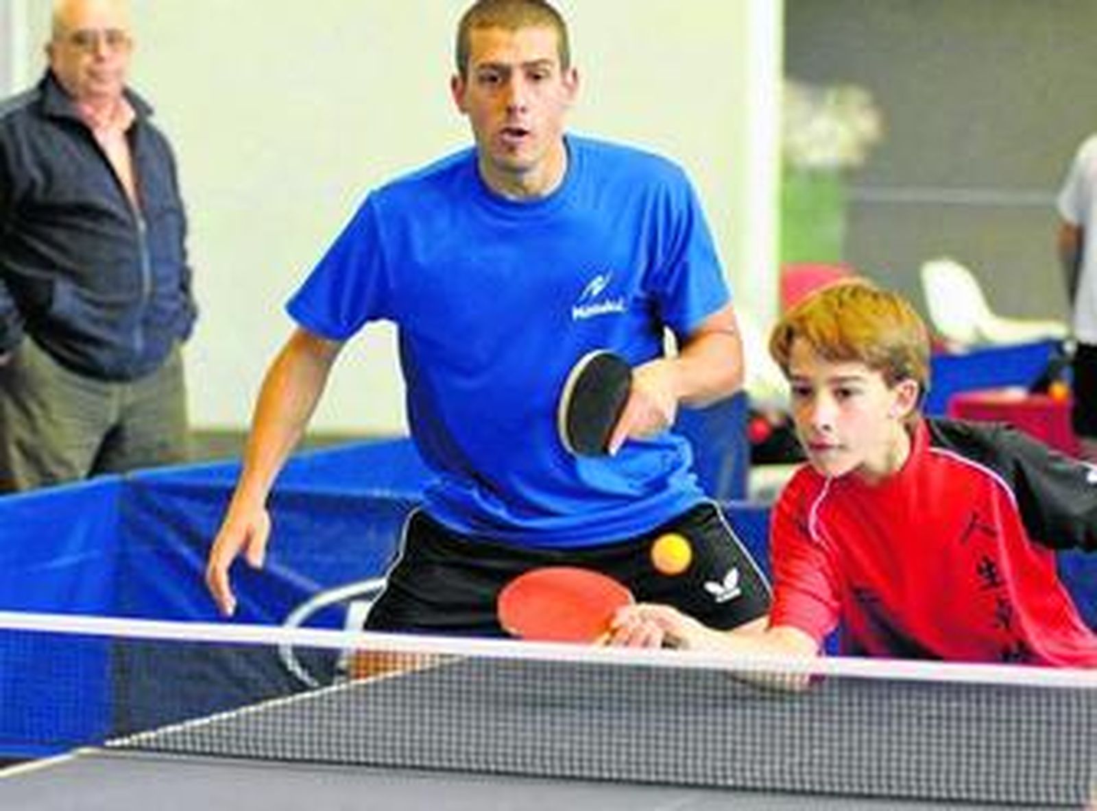 José Manuel Caballero golpea la bola en presencia de Adrián Robles durante un partido de dobles.