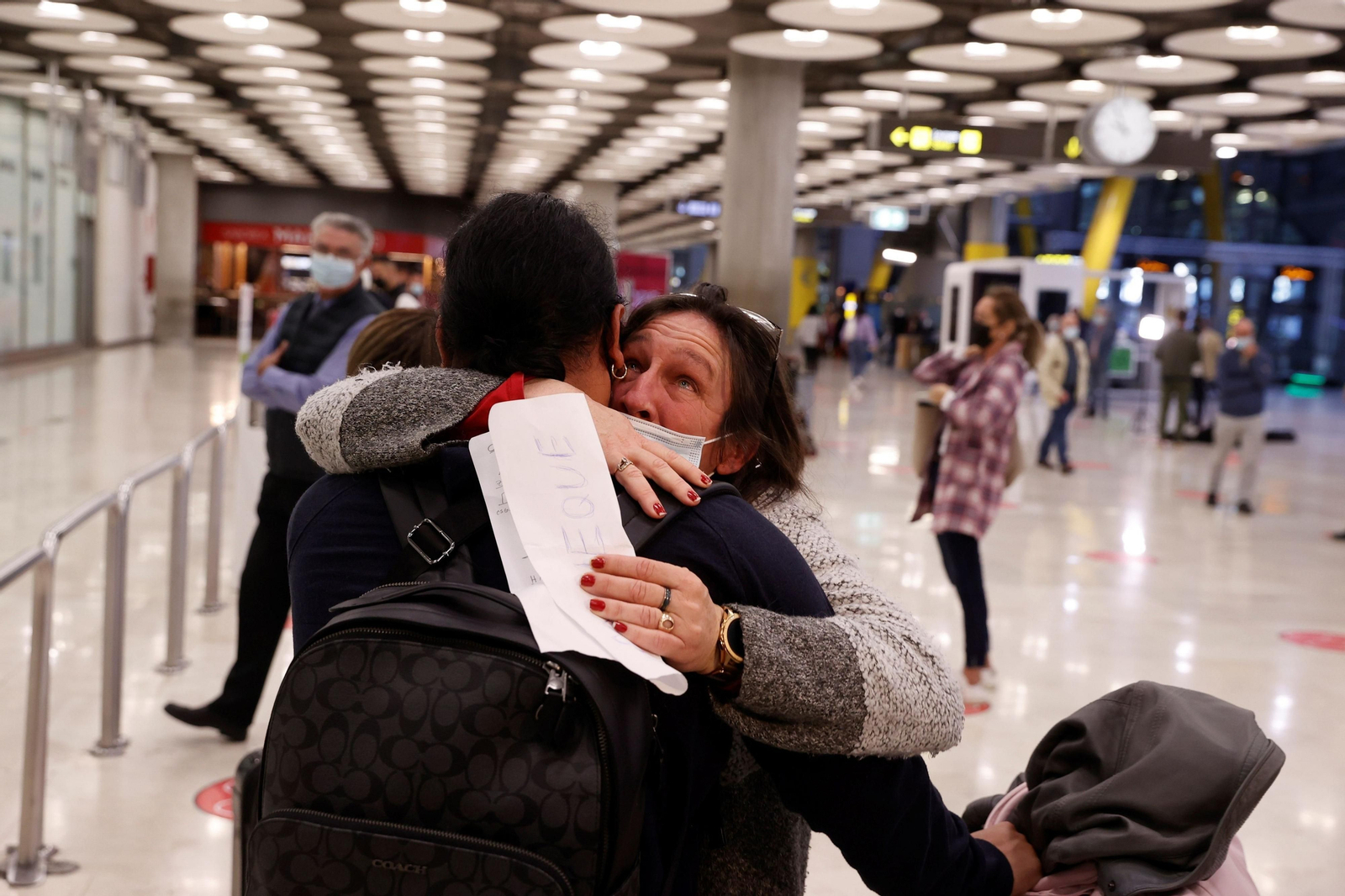 Una madre se despide de su hijo en el aeropuerto de Barajas