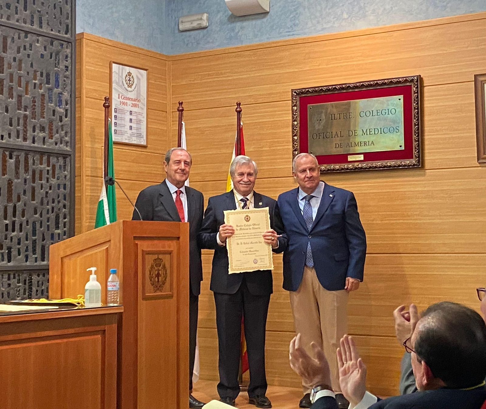 Rafael Morcillo recibe la Medalla de Oro  del colegio de Médicos y un Diploma acreditativo de manos del presidente y el secretario de la entidad.