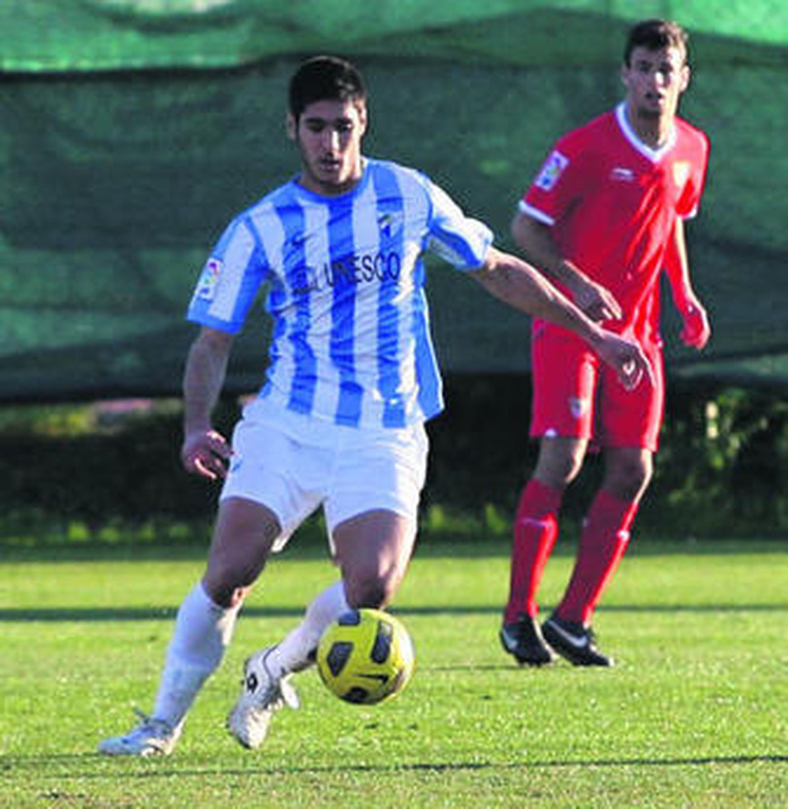 El delantero del Málaga Pedro controla ante un rival.