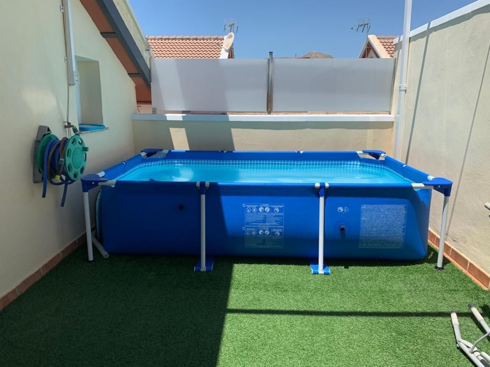 Piscina portátil ubicada en la terraza de una vivienda unifamiliar.