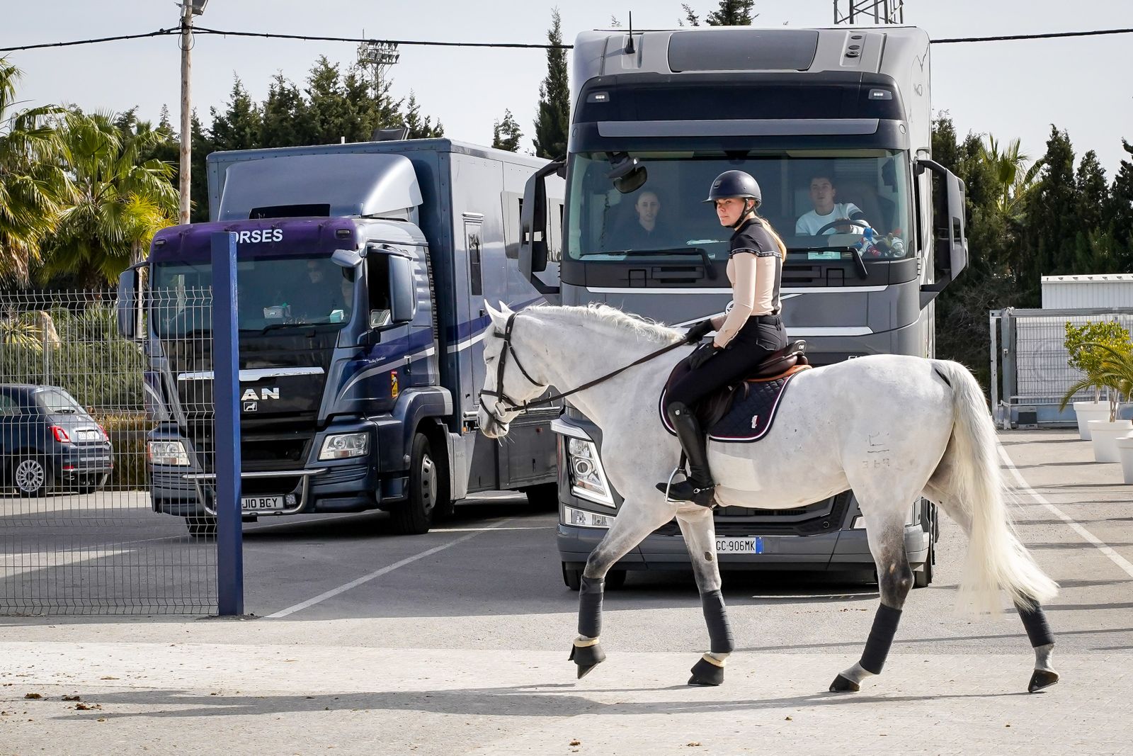 Una jinete con su caballo y camiones en Montenmedio.