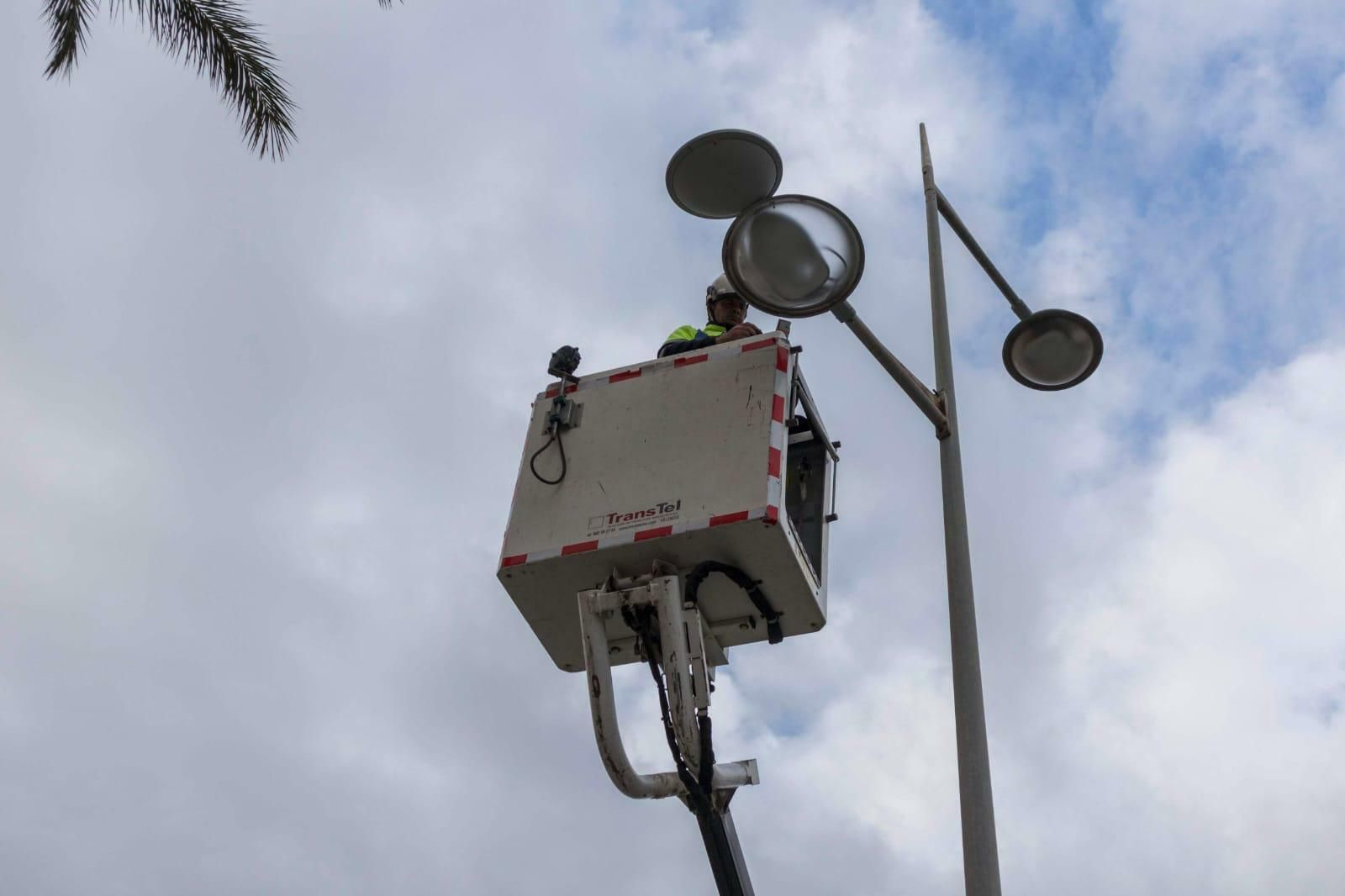 Operario reparando una de las farolas de la capital