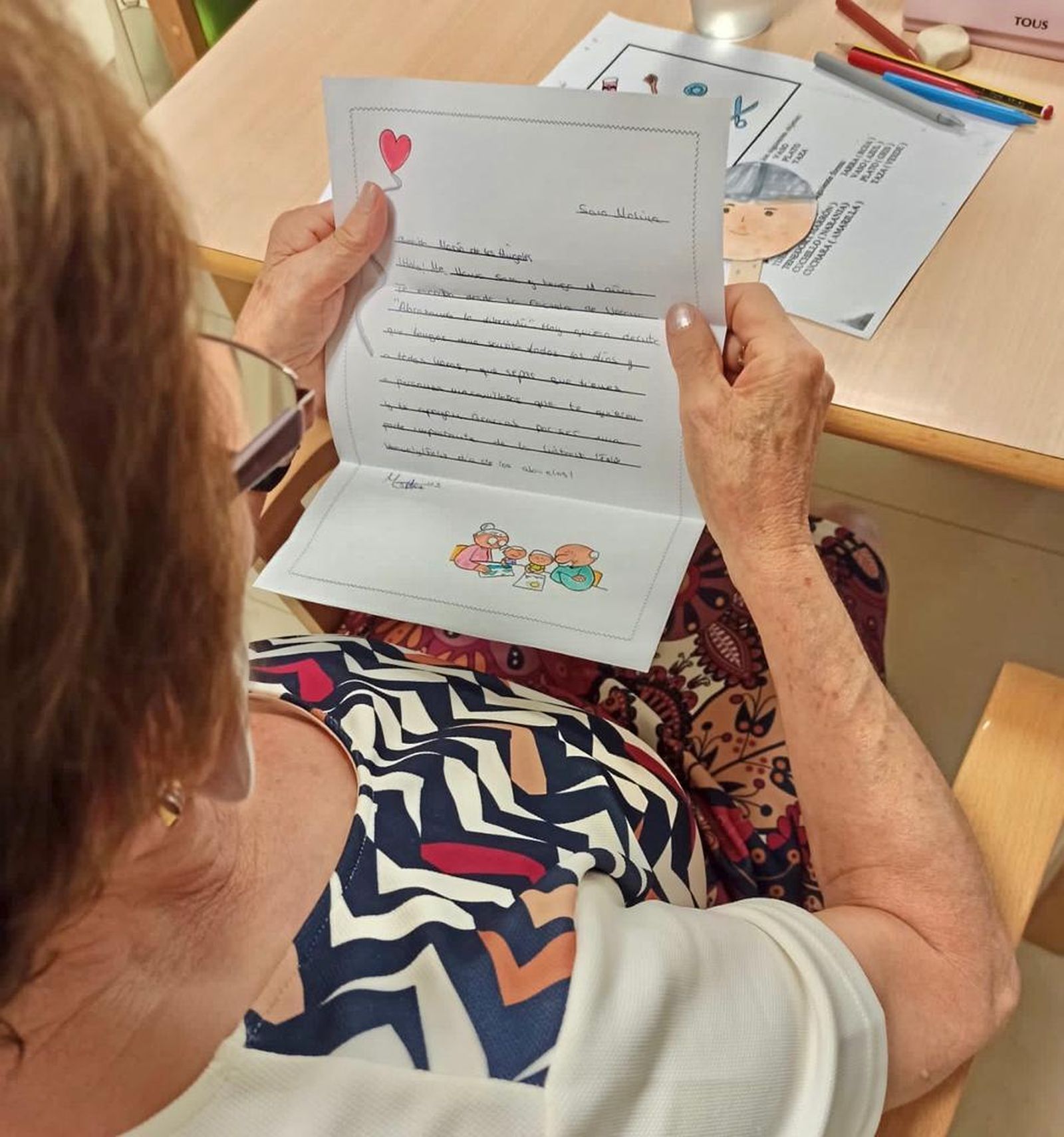 Una persona mayor lee una carta enviada por uno de los niños del municipio.