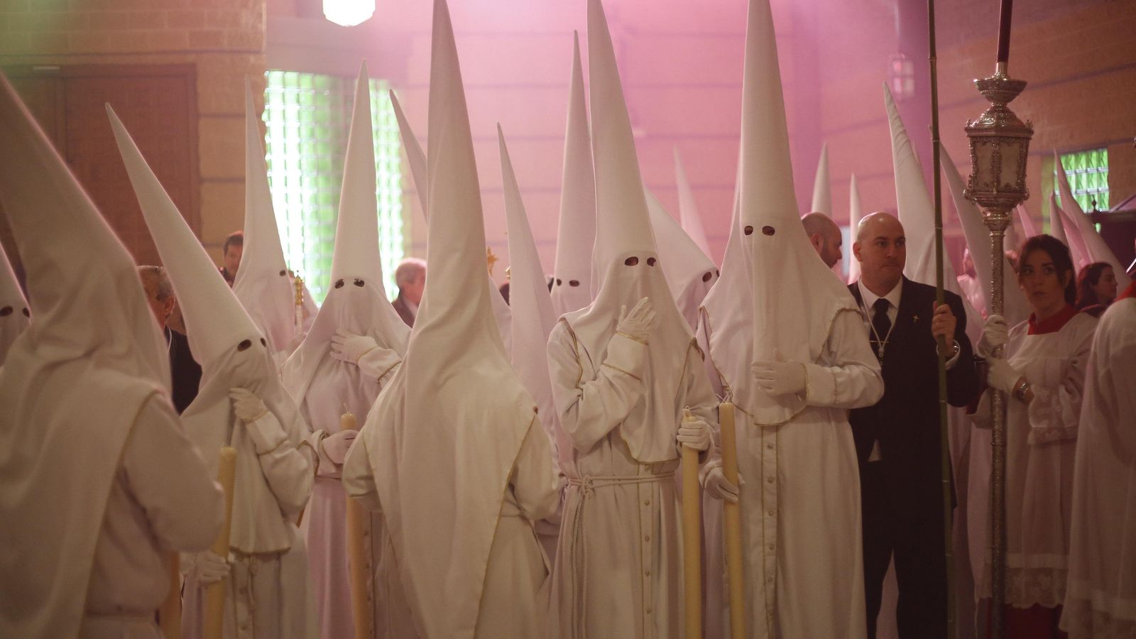 Las túnicas de nazareno de La Resurrección son blancas y con los filos de antifaz y túnica dorados