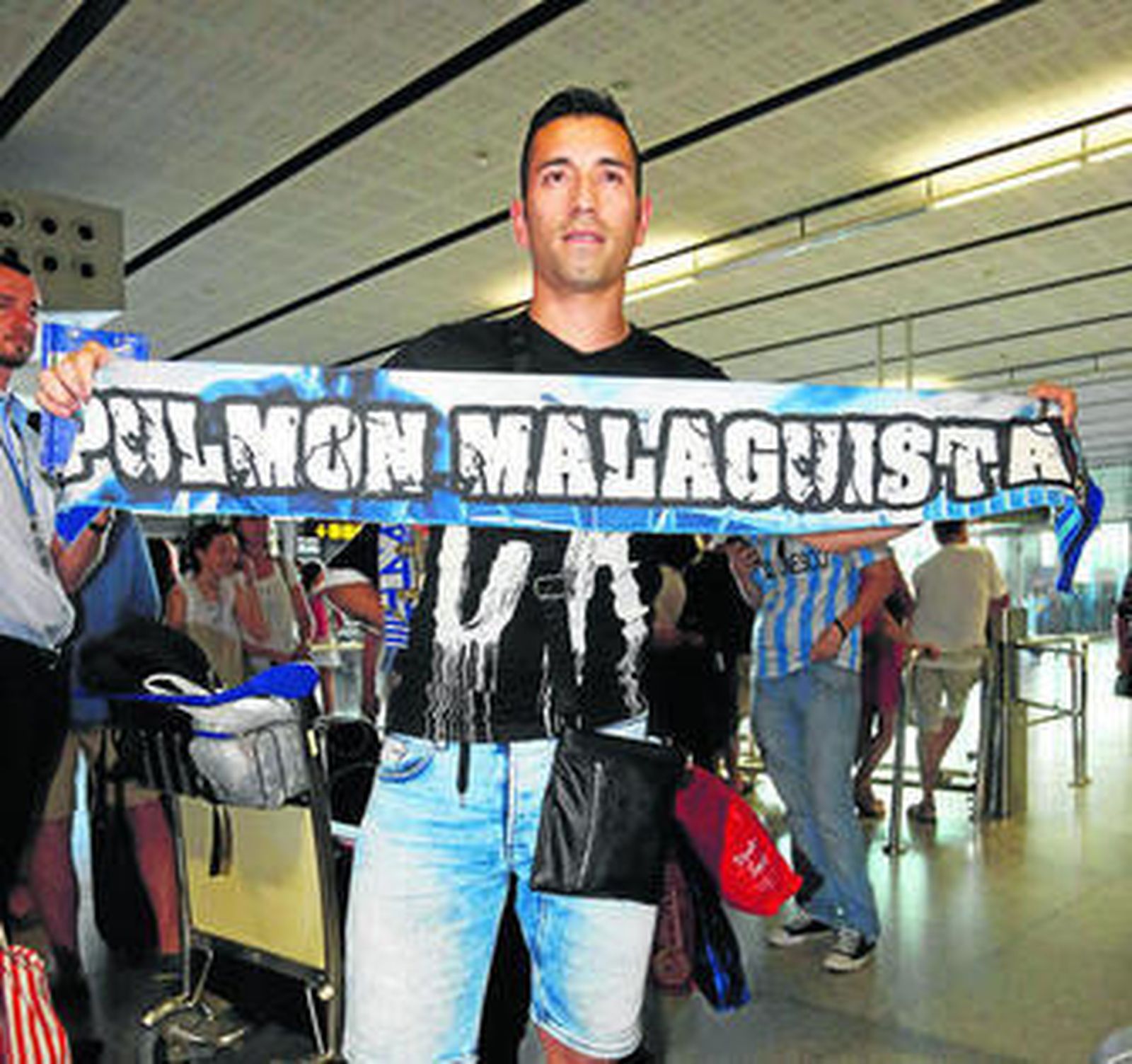Charles posa con una bandera malaguista, a su llegada al aeropuerto costasoleño.