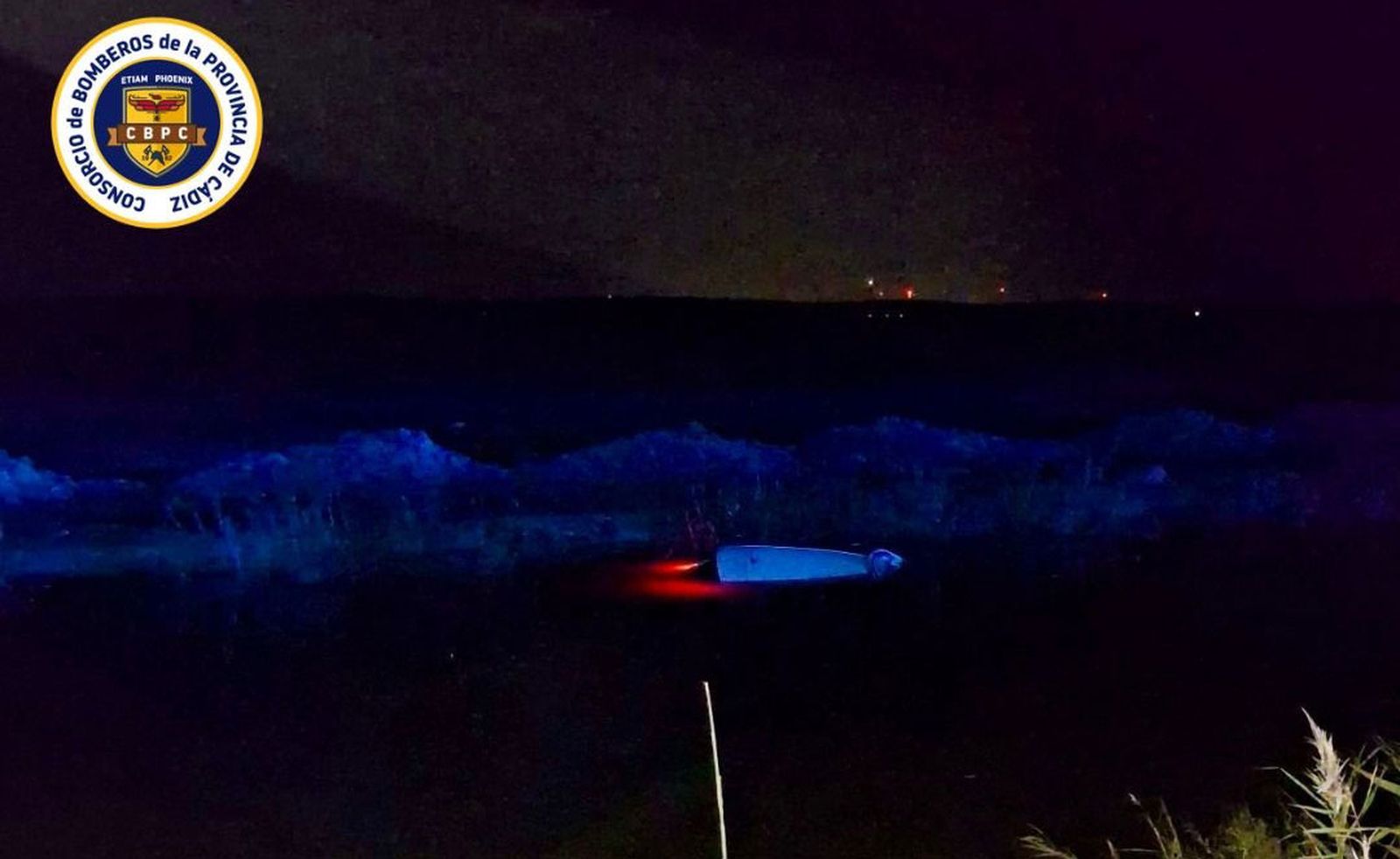 Coche hundido en un canal de Sanlúcar del que sólo sobresale el techo.