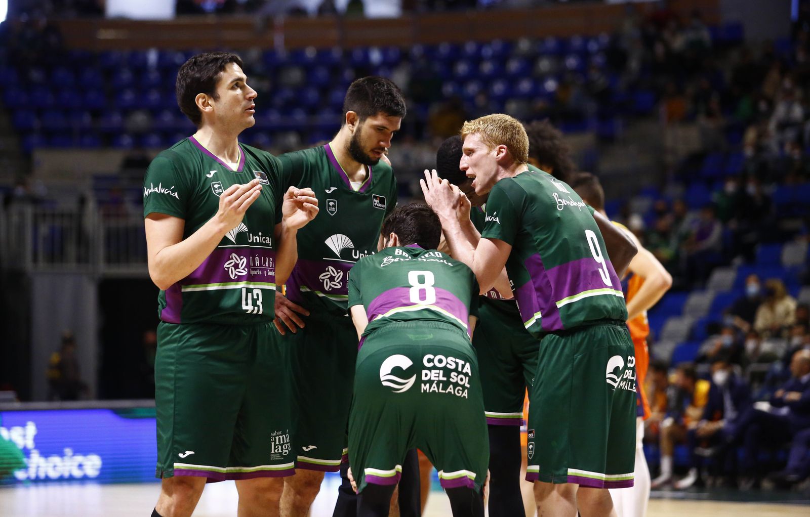 Varios jugadores del Unicaja hablan en la pista del Carpena.