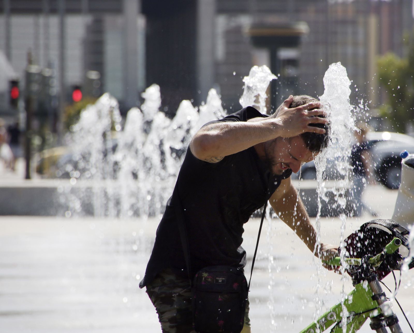 Un hombre se refresca en el Vial Norte.