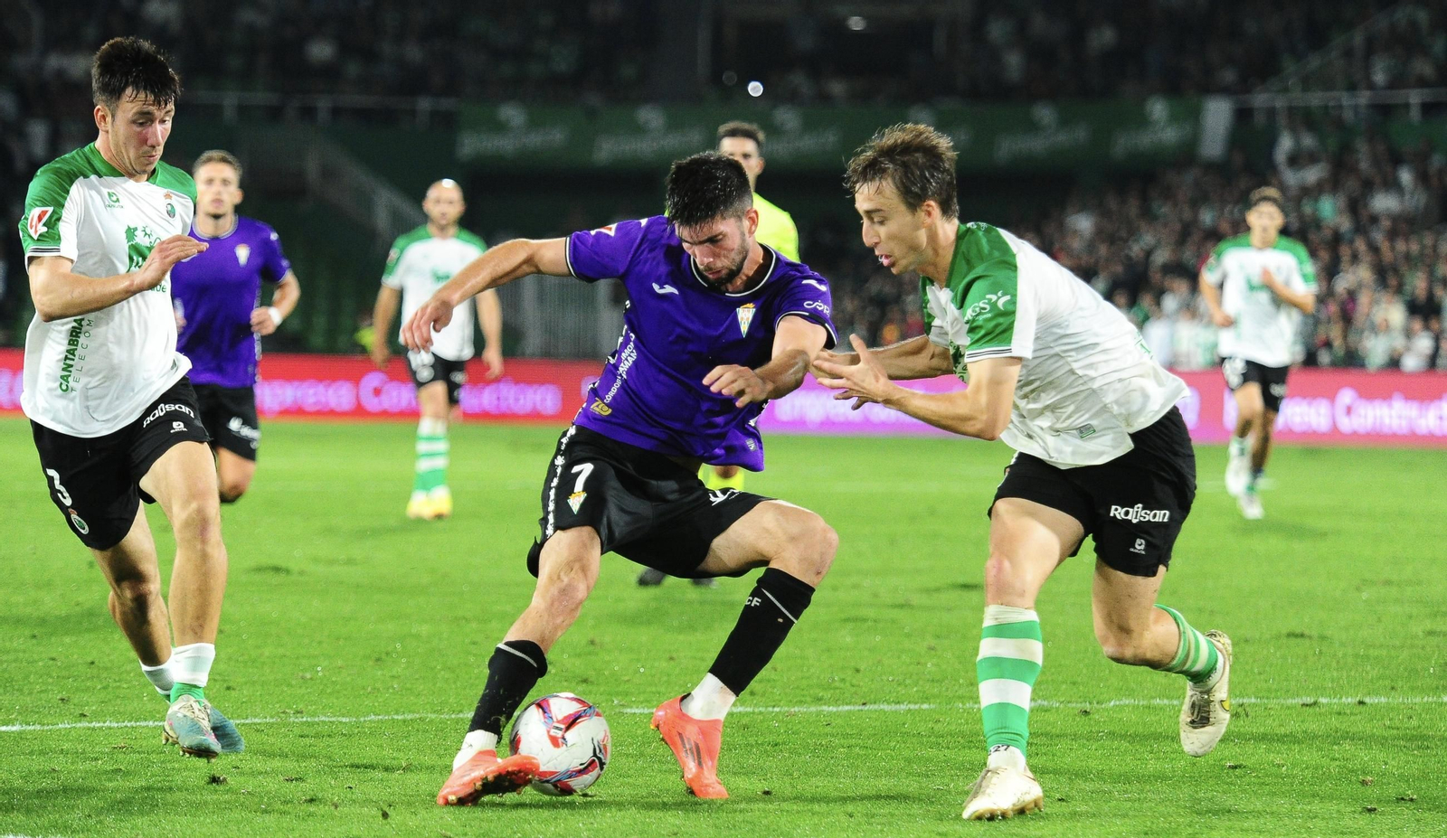 Théo Zidane intenta zafarse de la presión de dos defensores racinguistas.