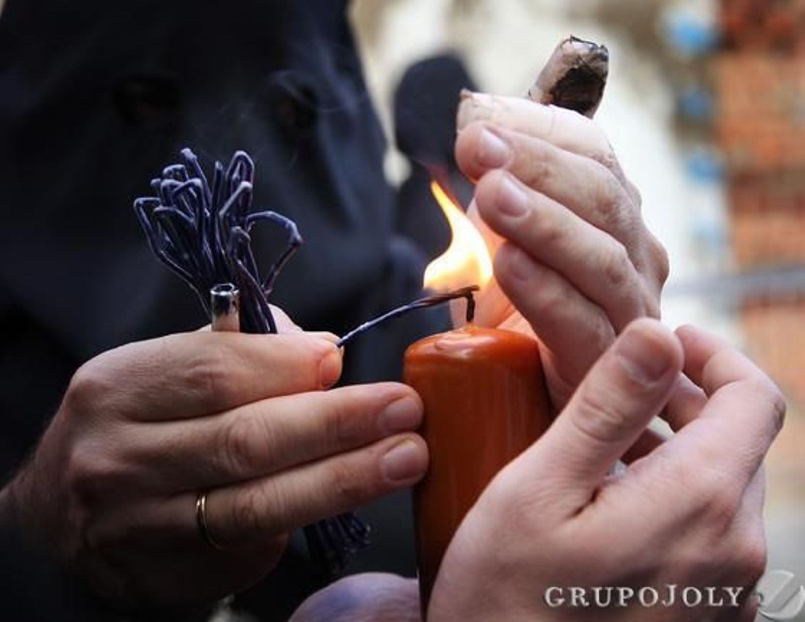 Un monaguillo ayuda a un nazareno de la hermandad a encender el cirio a la altura de la calle Granados.

Foto: Vanesa Lobo