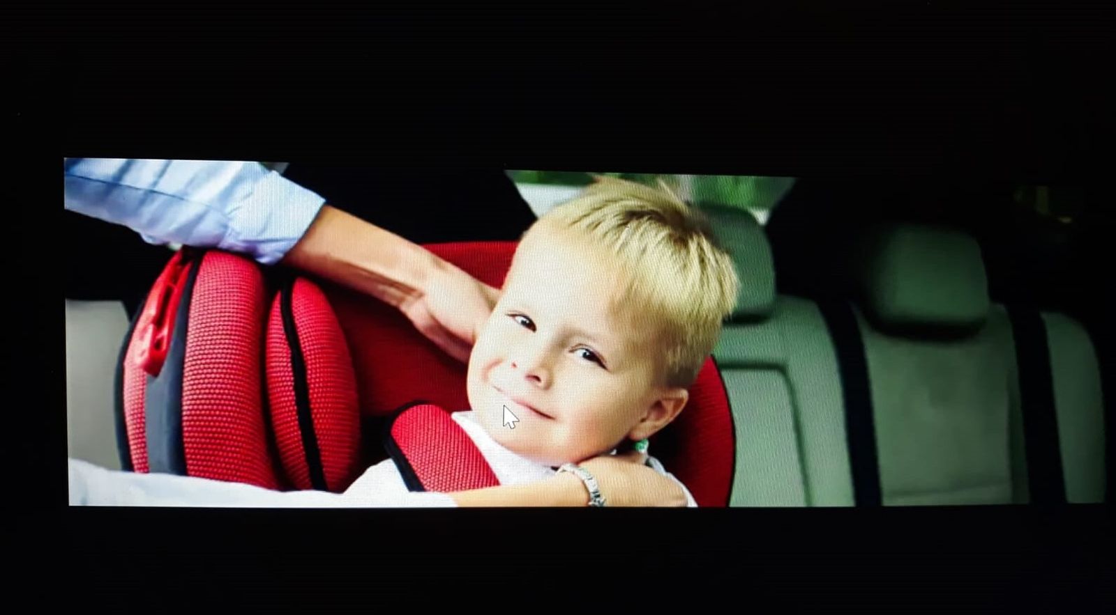 Un menor en la silla infantil de un vehículo.