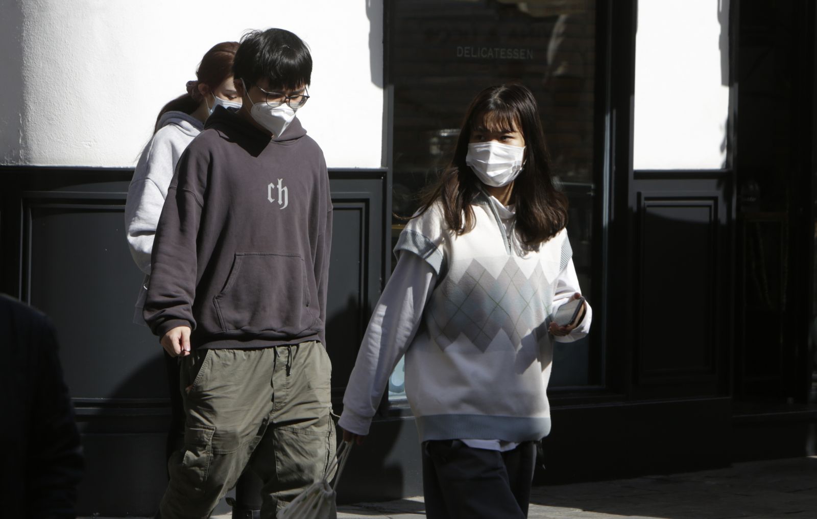 Dos jóvenes, con mascarilla por la calle.
