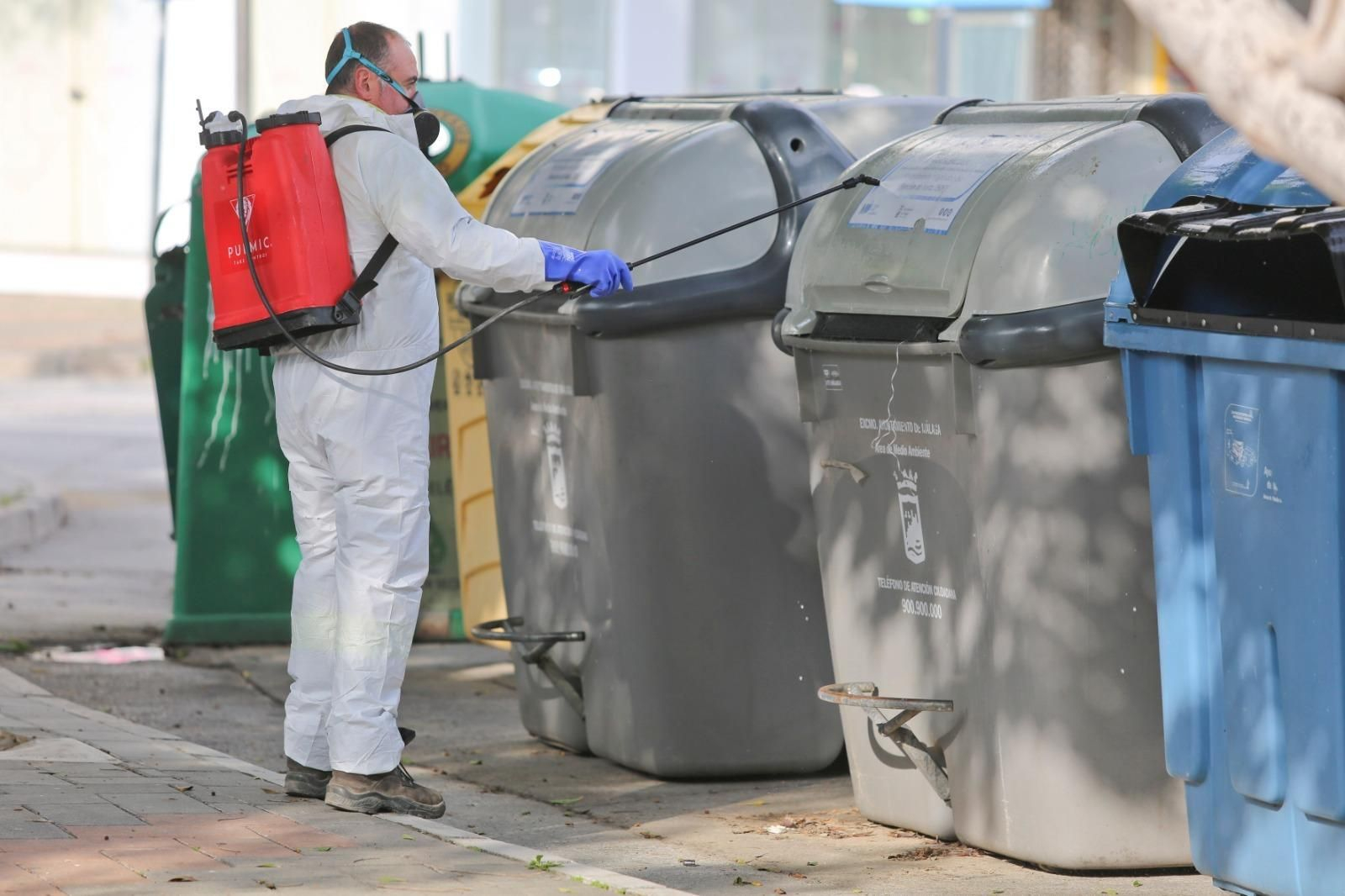 Un trabajador de Limasa desinfecta los contenedores de basura.