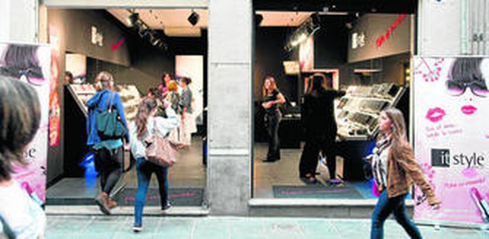 Transeúntes acceden a un establecimiento en las calles de Granada.