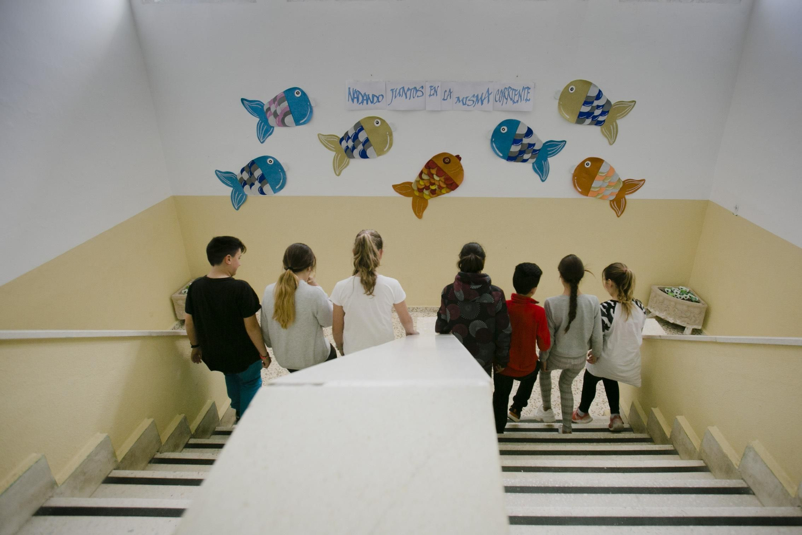 Varios niños bajan las escaleras en el CEIP Juan Carlos Aragón.