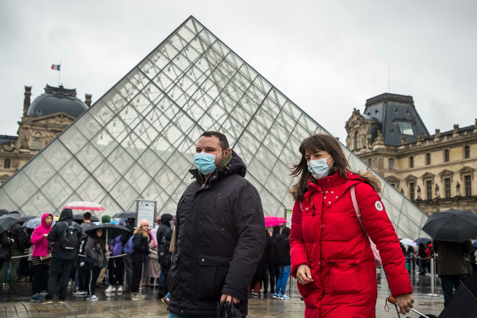 Un par de turistas en las afueras del Louvre