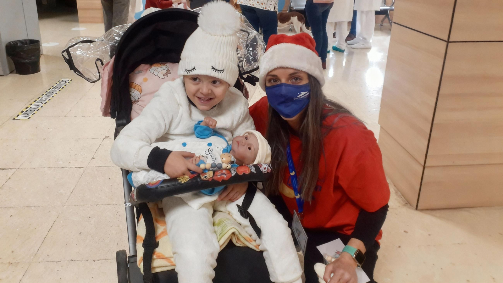 Indhara junto al bebé vestido de azul que le ha facilitado la asociación Pídeme la Luna