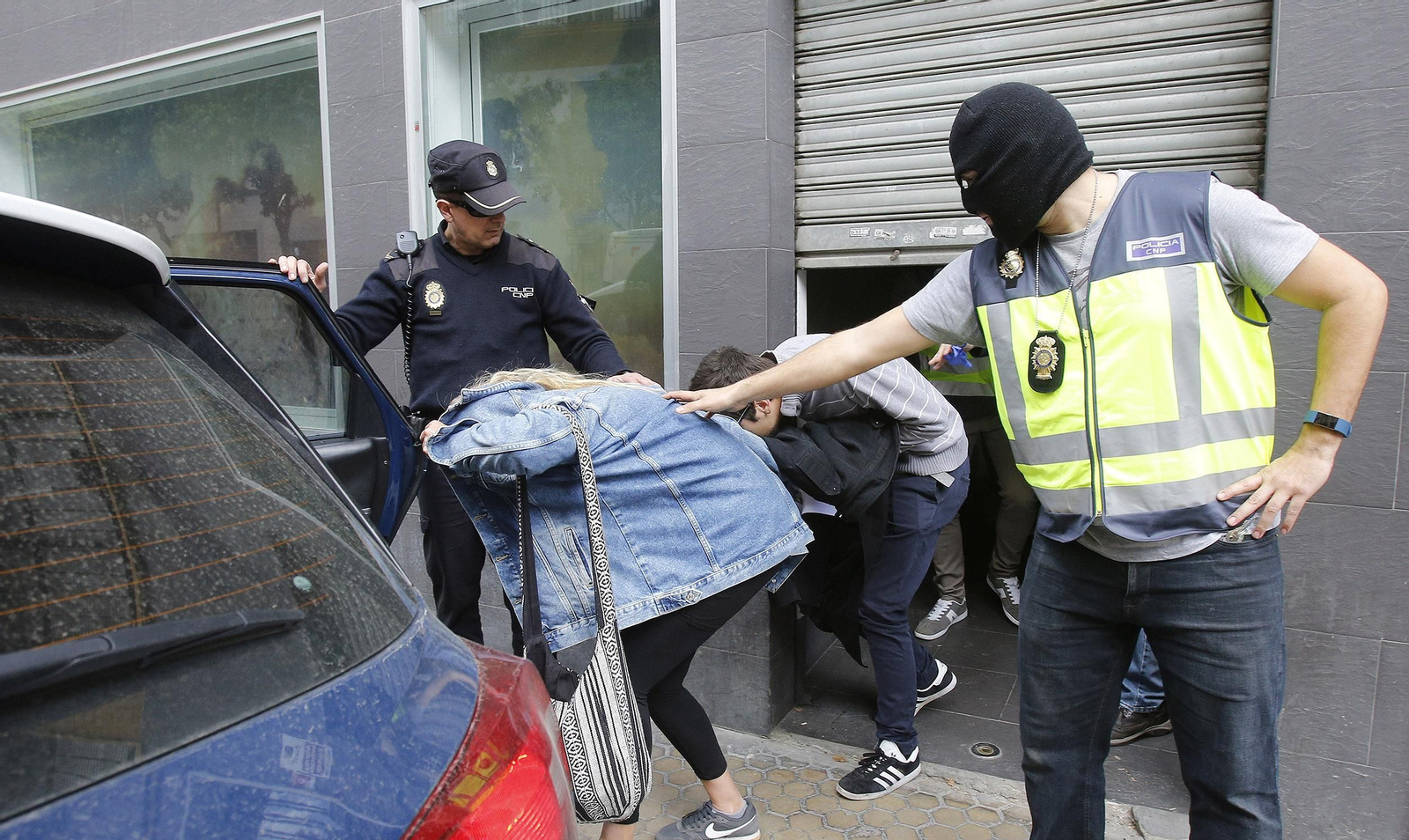 La Policía saca a los dos detenidos del local, a mediodía de ayer.