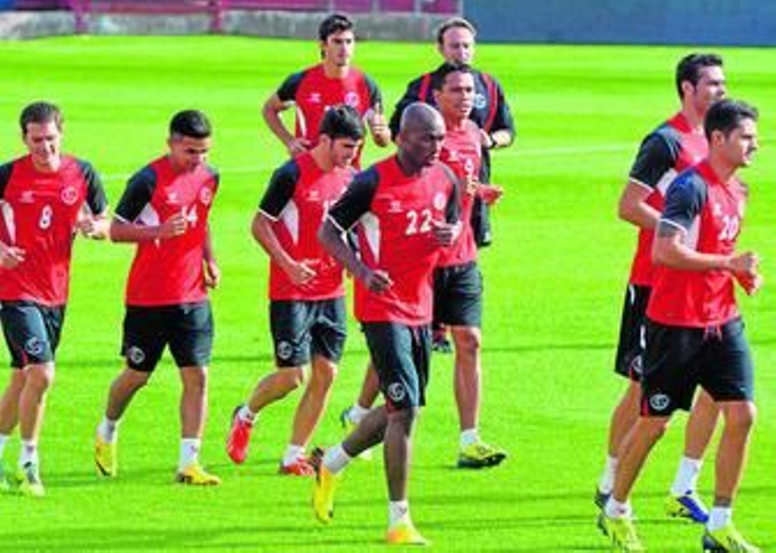 Un nutrido grupo de jugadores del Sevilla realiza carrera continua.