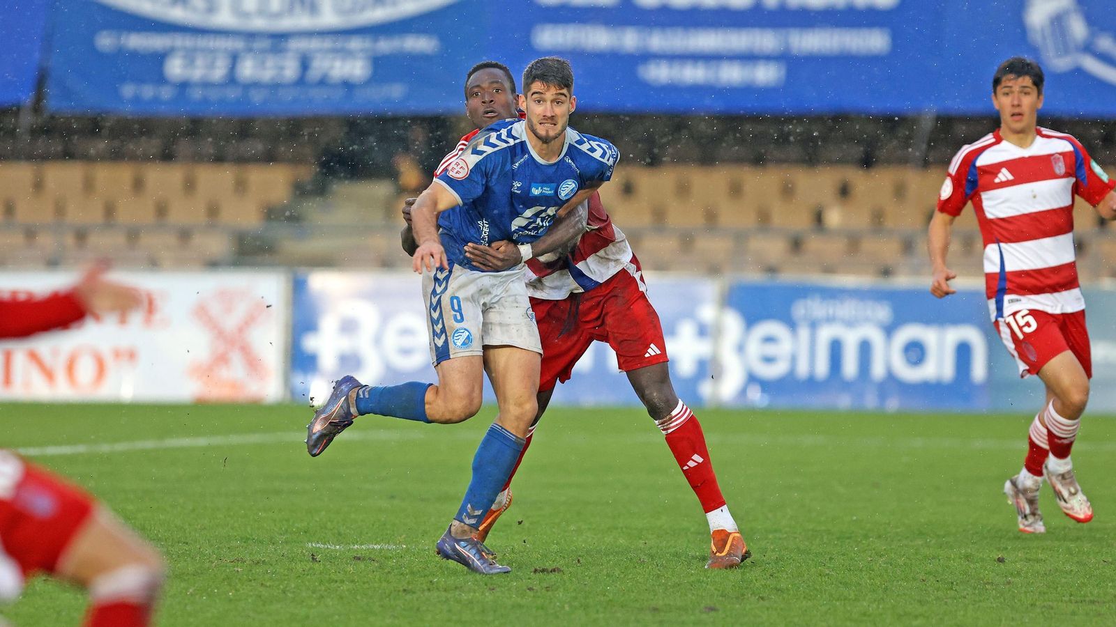 Abraham, agarrado por un contrario en el partido ante el Recreativo Granada, al que le hizo cuatro goles con dos dobletes.