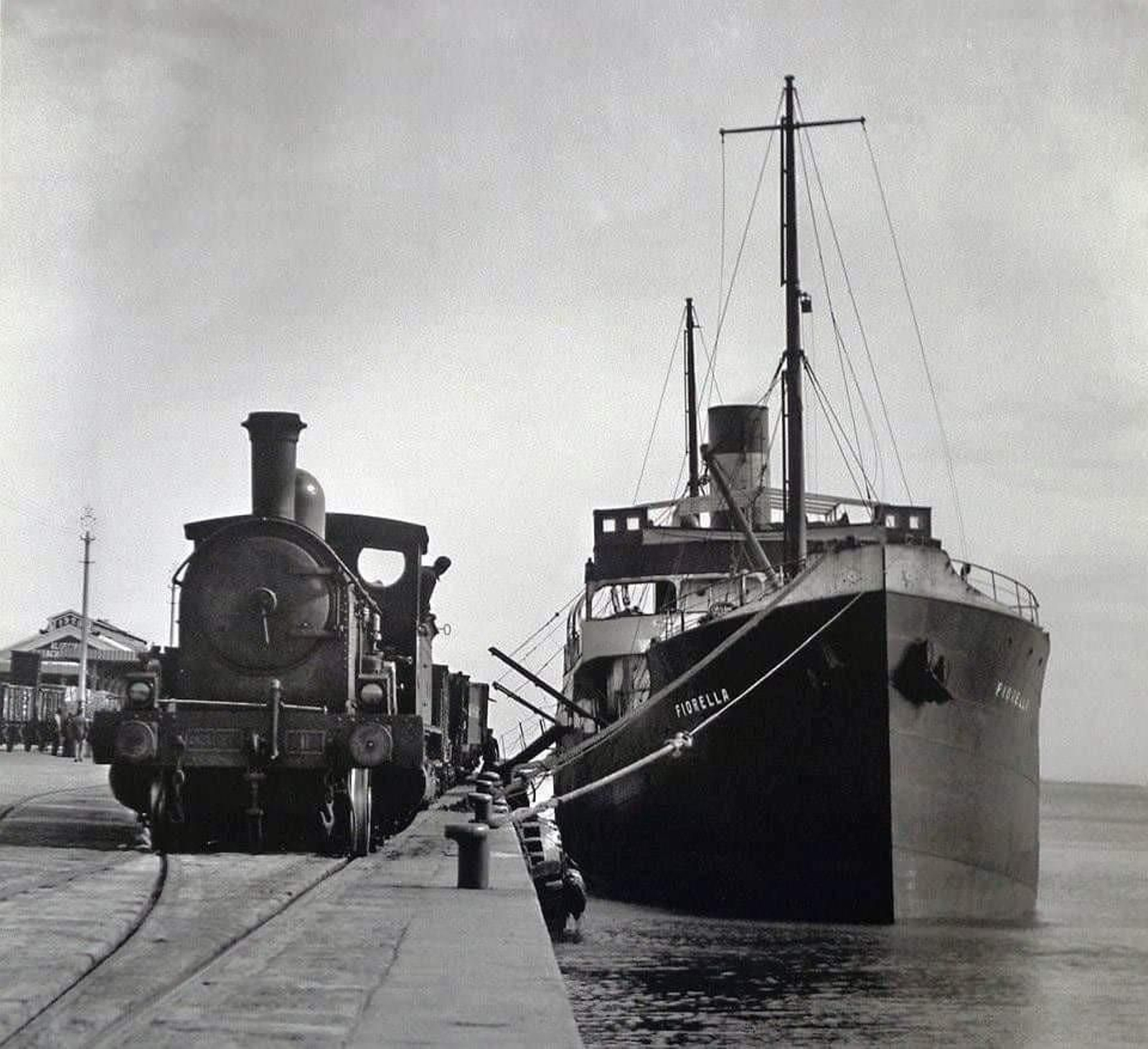 El buque italiano 'Fiorella' atracado en el muelle de la Galera esperando embarcar las mercancías llegadas en un tren. Año 1929 (Archivo de la A.P.B.A.). El buque italiano 'Fiorella' atracado en el muelle de la Galera esperando embarcar las mercancías llegadas en un tren. Año 1929 (Archivo de la A.P.B.A.).