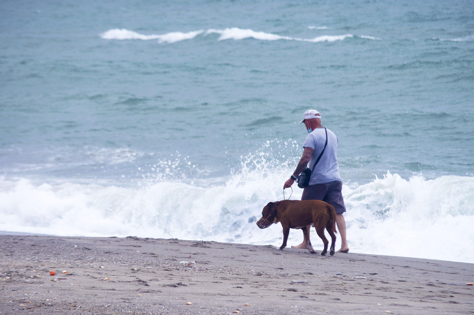 Una persona camina con mascarilla por una playa de La Línea, este lunes.