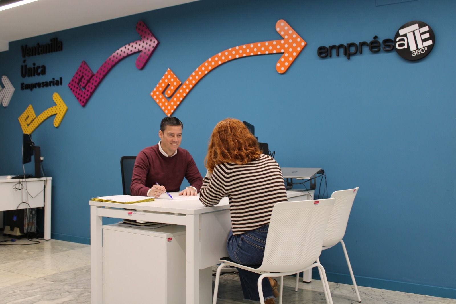 Un profesional de la Ventanilla Única Empresarial asesora a una emprendedora.