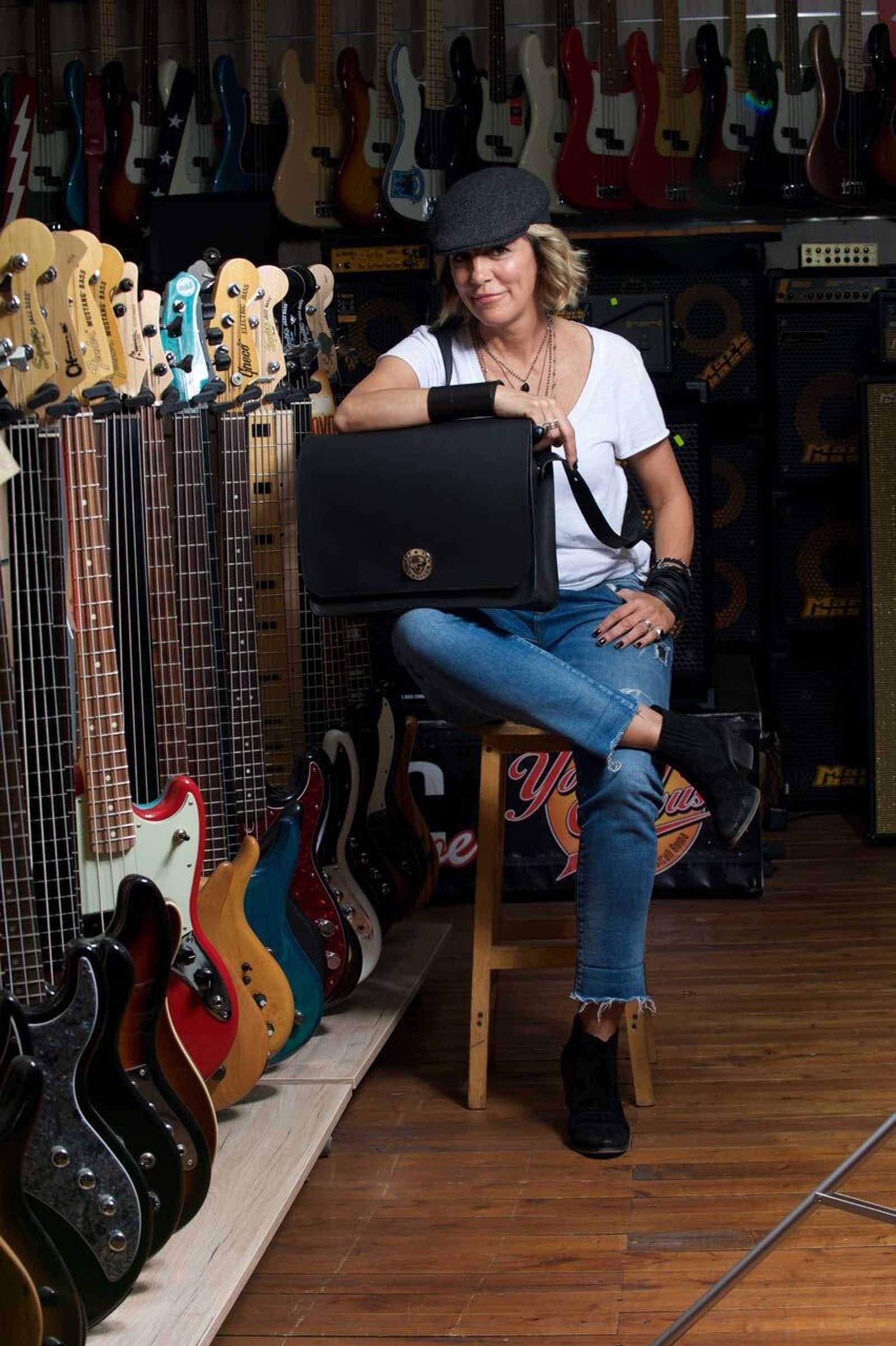 María José Carral con uno de sus bolsos, rodeada de guitarras eléctricas.