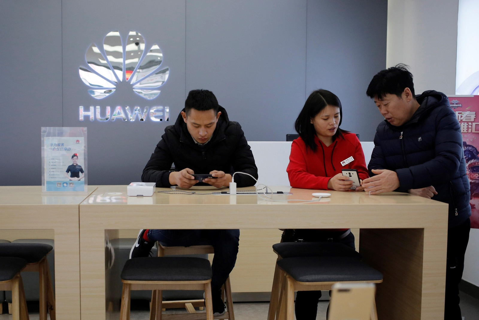 Una vendedora atiende a un cliente en una tienda Huawei en Pekín (China).