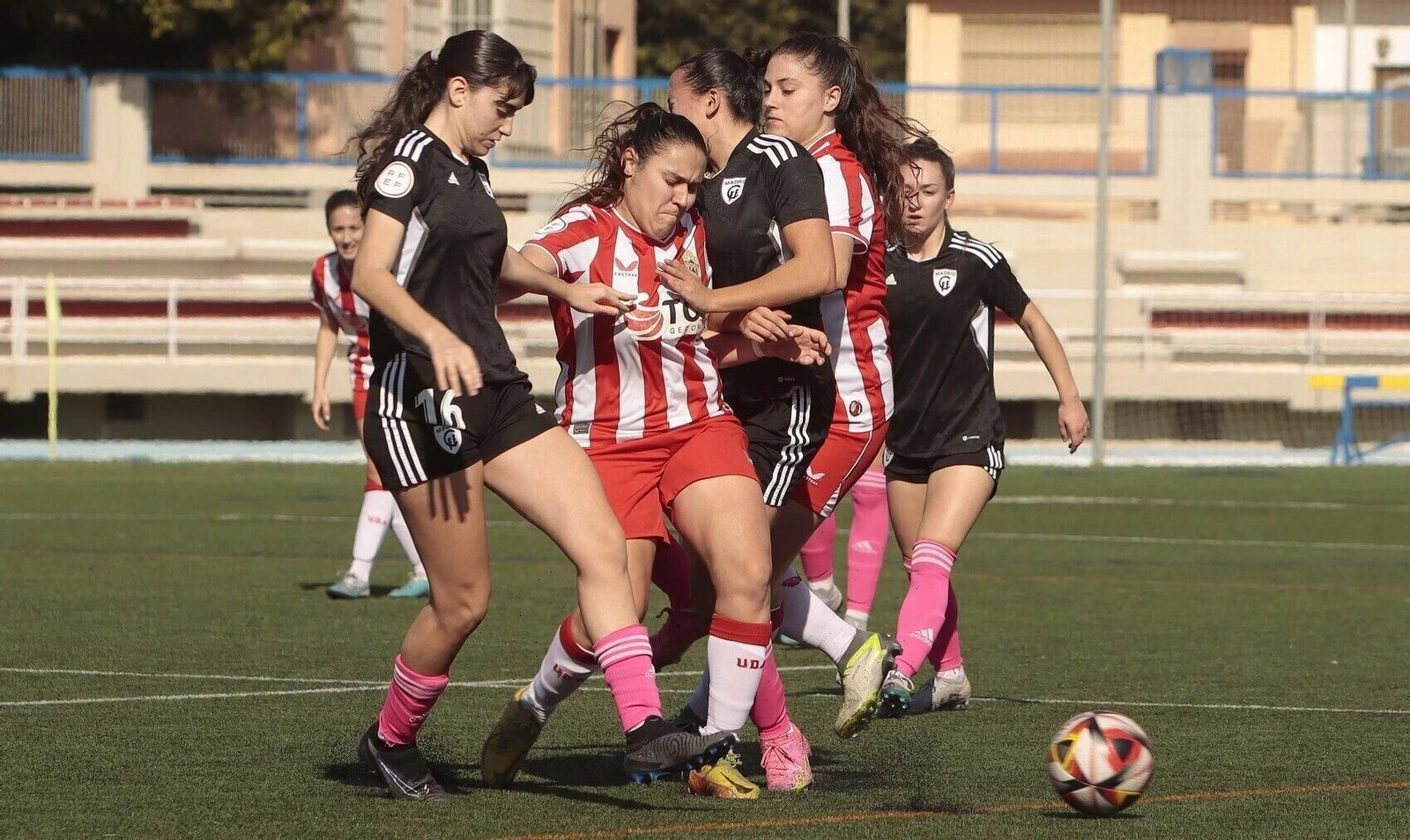La rojiblanca Paqui intenta zafarse de la entrada de dos rivales durante el partido frente al Madrid CFF C.