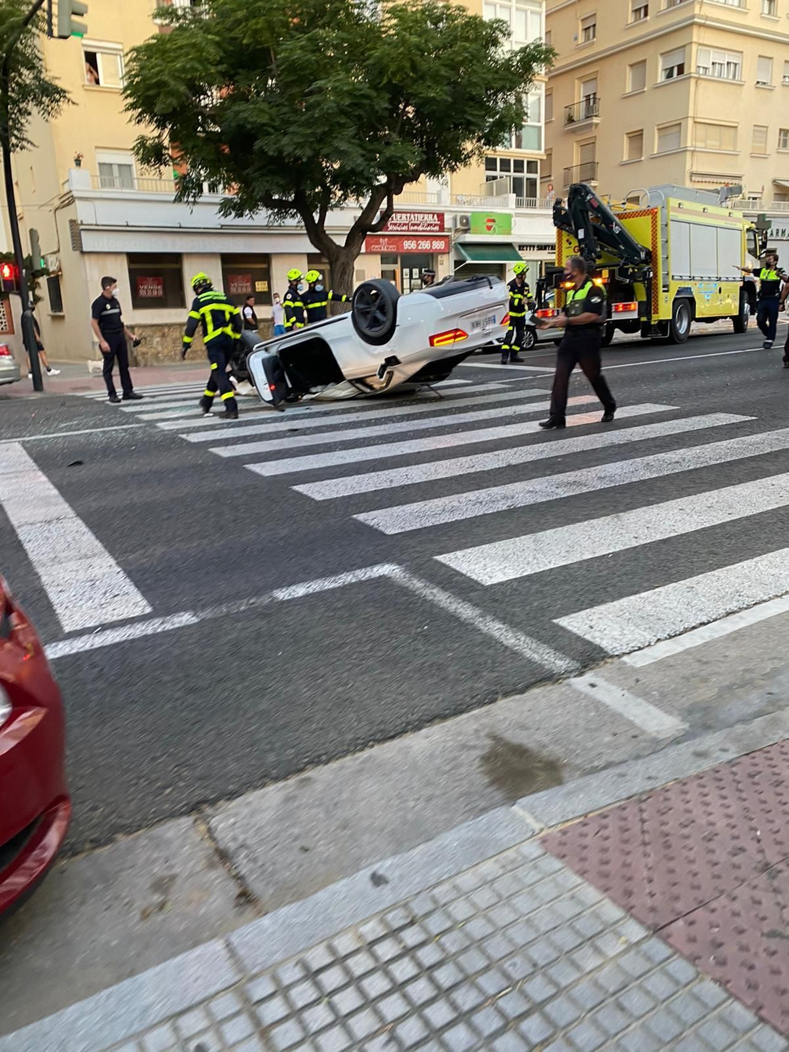 Imagen del coche volcado en la avenida.