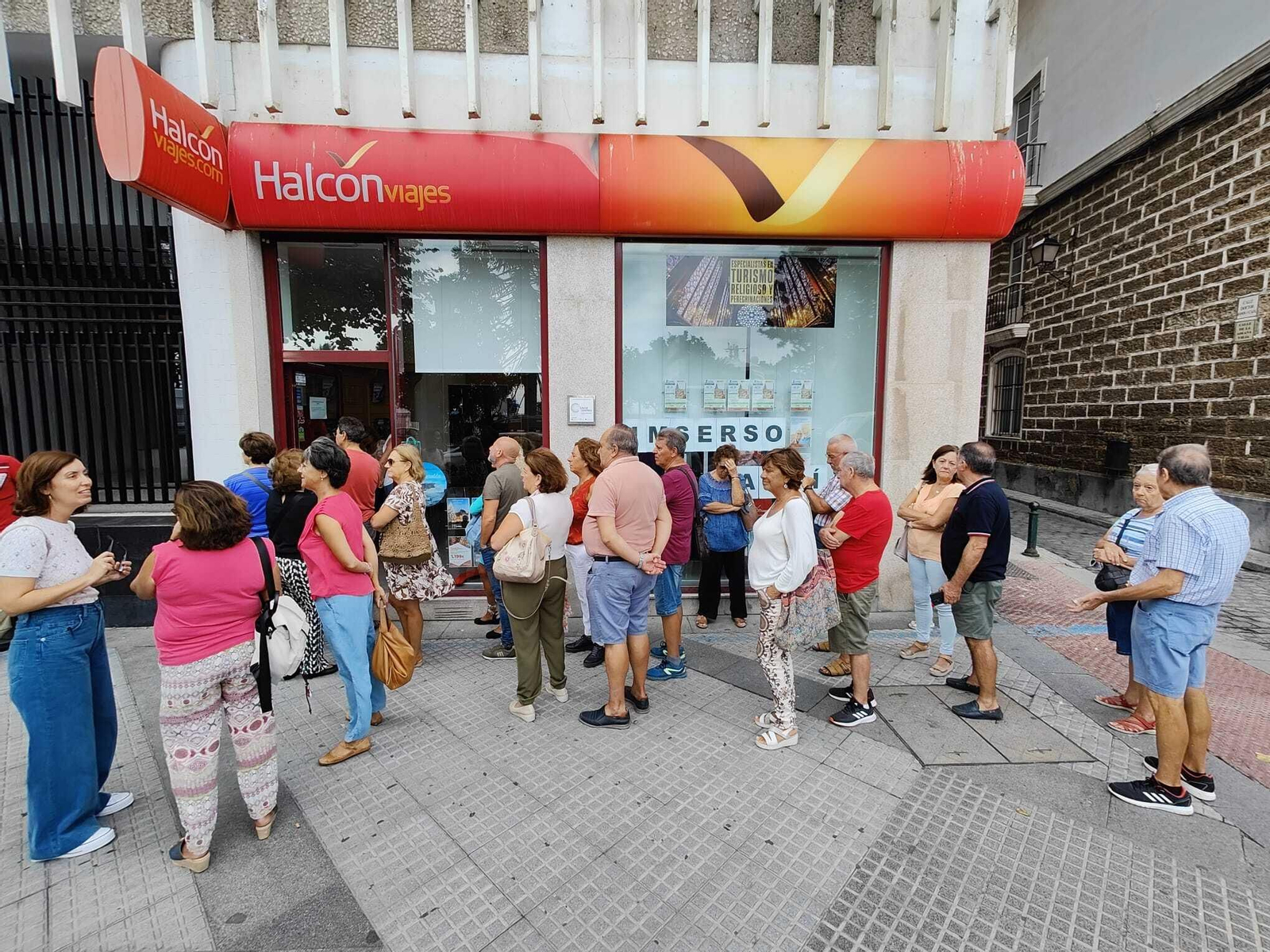 Un grupo de personas esperando fuera de una agencia de viajes en la capital gaditana.