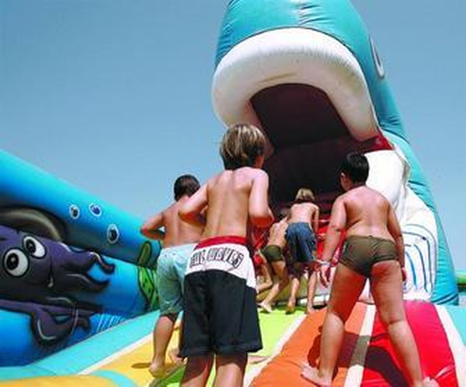 Varios niños juegan en uno de los muñecos hinchables de La Ballena Azul.