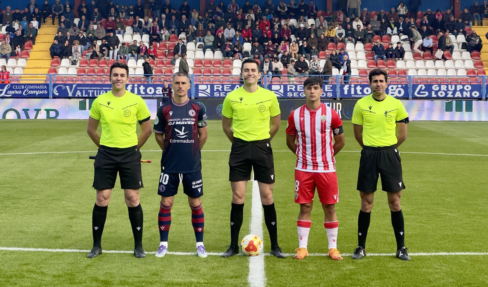 Los capitanes del Extremadura y del Almería B posan con el trío arbitral antes del comienzo del encuentro.
