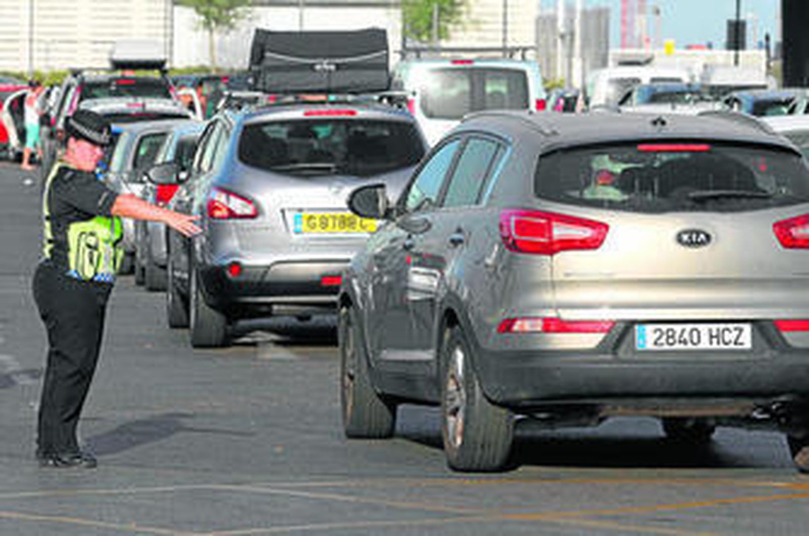 Una policía gibraltareña dirige el tráfico ayer, cuando se registraron de nuevo colas para salir del Peñón.