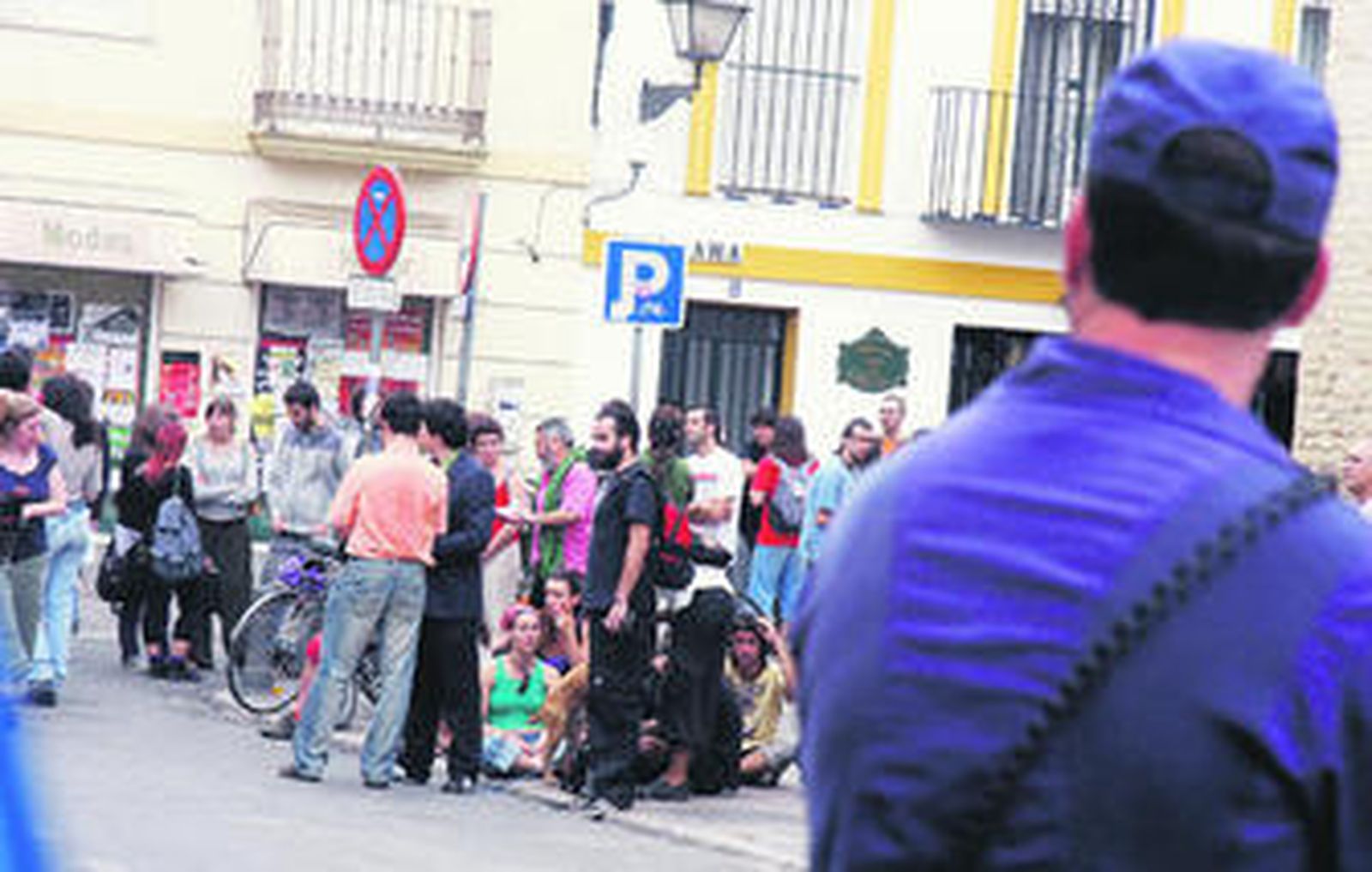 Un policía vigila a los 'okupas' desalojados de la antigua fábrica de sombreros de Sevilla el 6 de junio.
