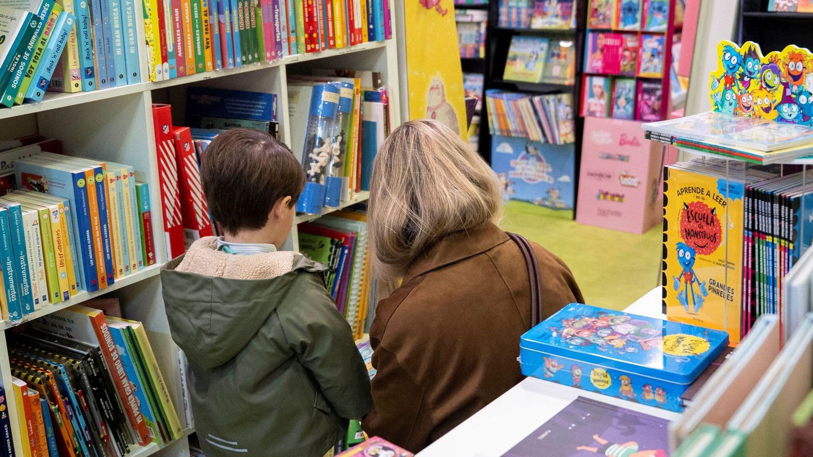 Una madre y su hijo pequeño rebuscan entre las estanterías de la librería Bibabuk.