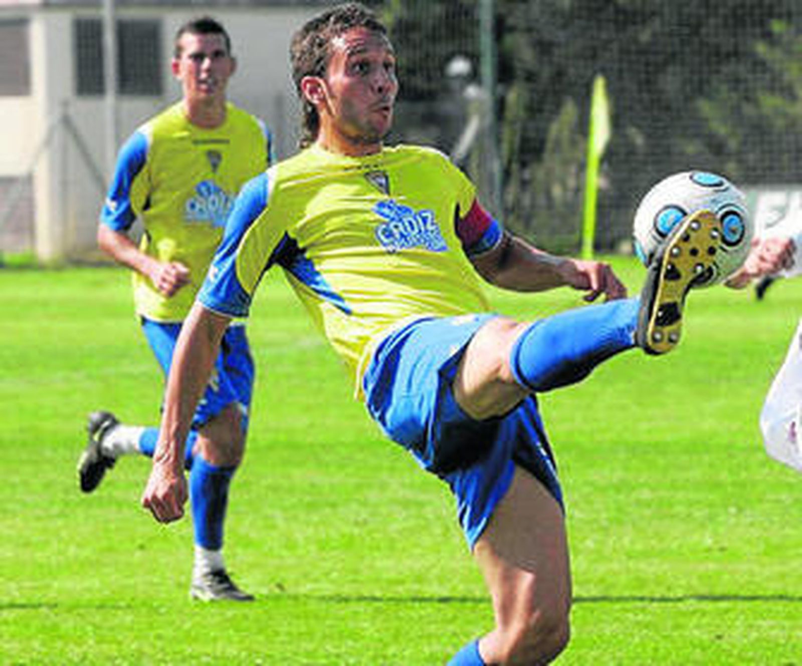 Germán golpea el balón mientras es observado por Caballero.
