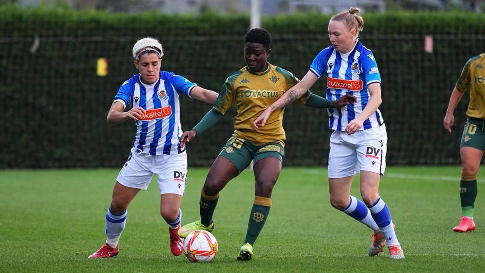 La bética Dorine trata de despejar ante la presión de dos jugadoras de la Real.