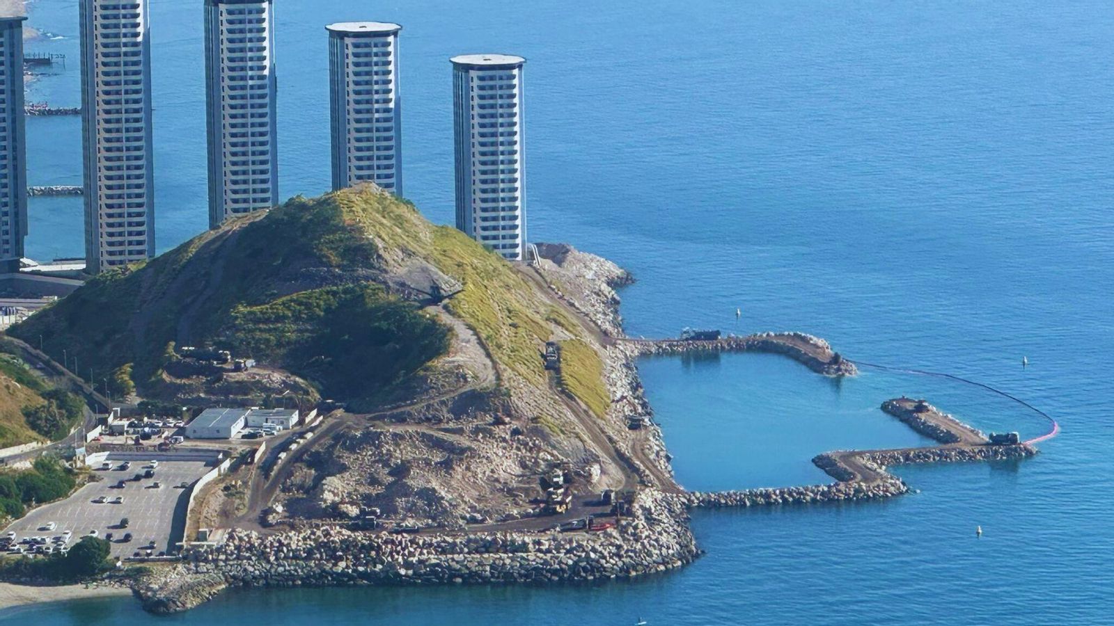 La montaña de escombros, los espigones construidos con piedra de escollera y, al fondo, las torres Hassan, en la cara este de Gibraltar. La montaña de escombros, los espigones construidos con piedra de escollera y, al fondo, las torres Hassan, en la cara este de Gibraltar.