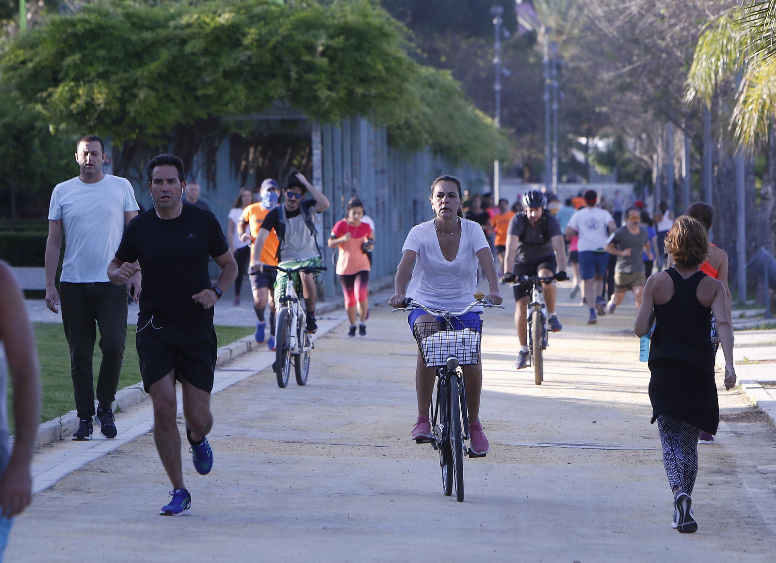 Varios deportistas sevillanos se ejercitan junto al río durante la primera jornada en la que se puede hacer deporte al aire libre.