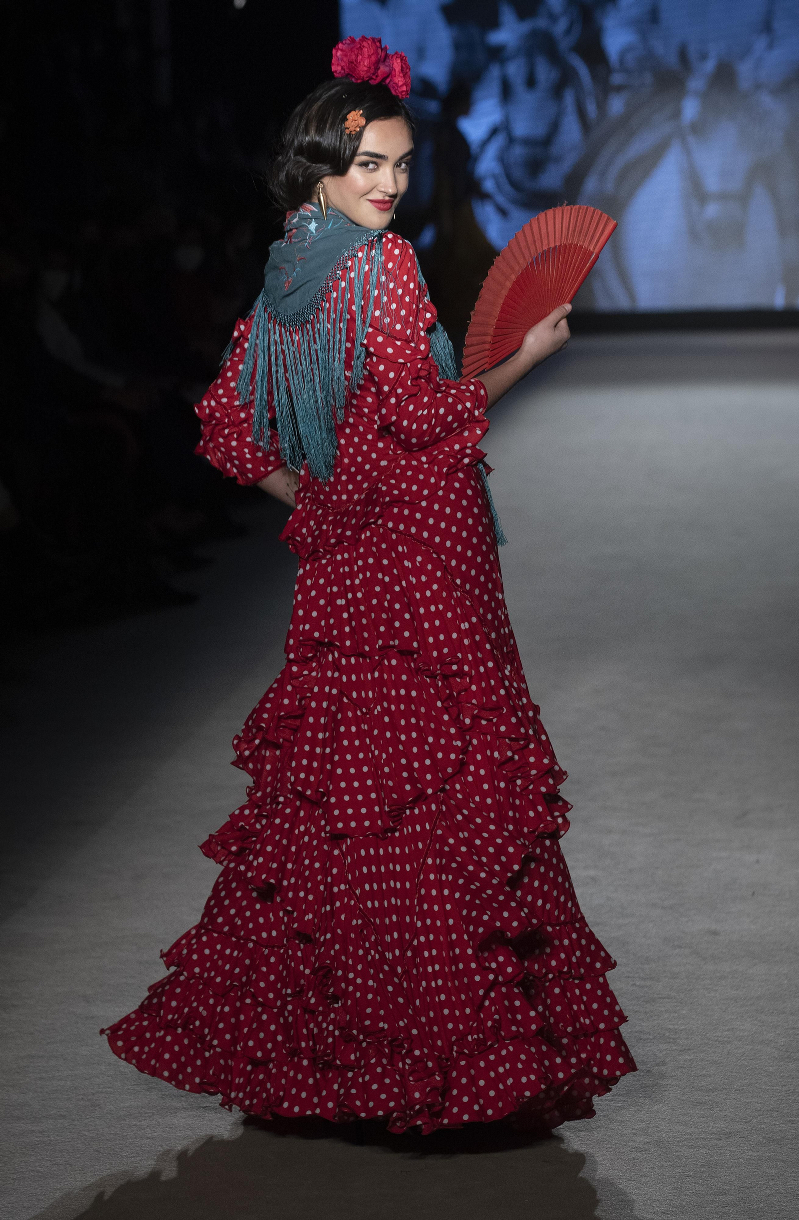 Traje de flamenca rojo combinado con mantoncillo azul petróleo de Rocío Olmedo. Traje de flamenca rojo combinado con mantoncillo azul petróleo de Rocío Olmedo.
