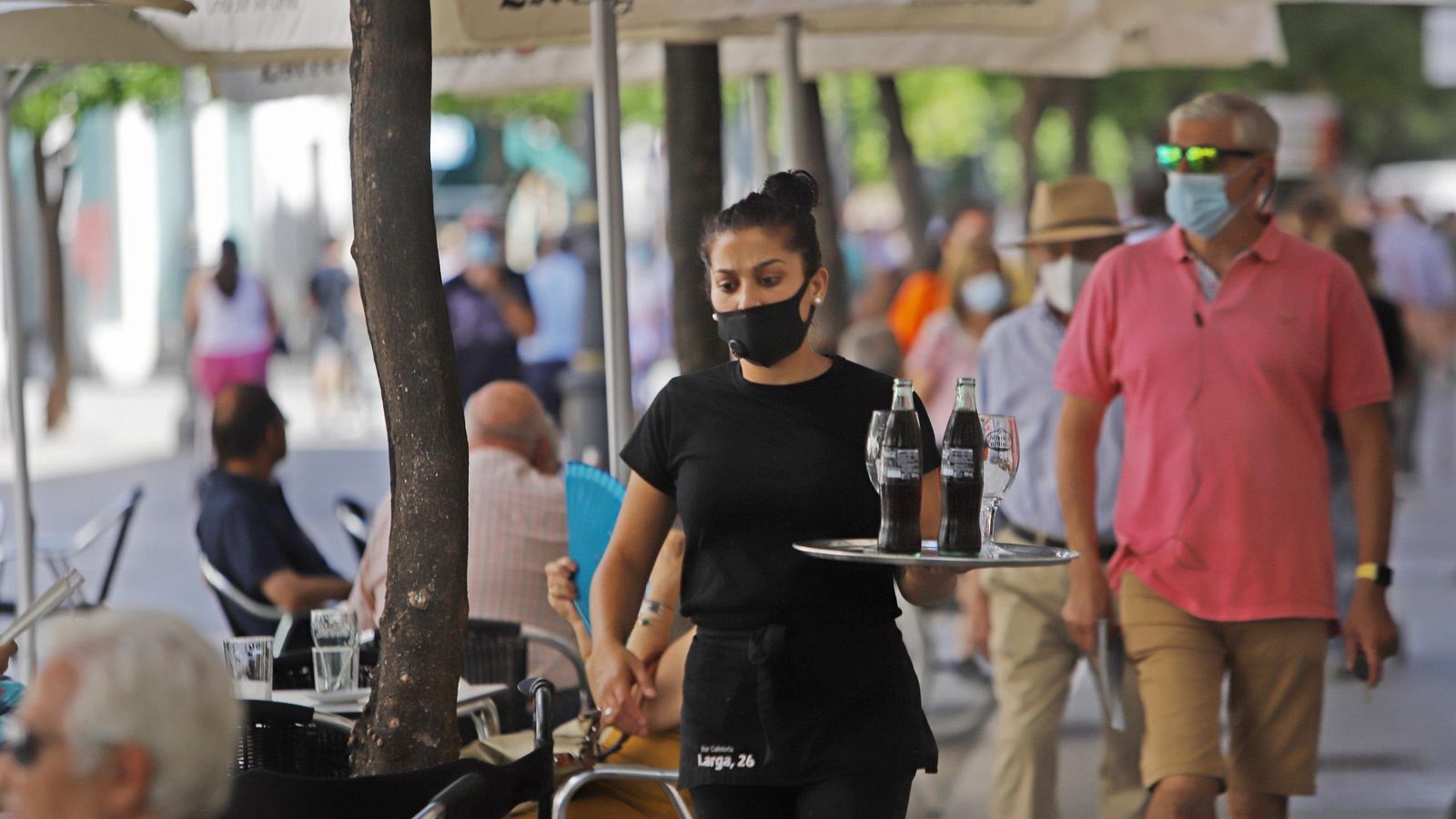 Una camarera en la terraza de un bar de la calle Larga.