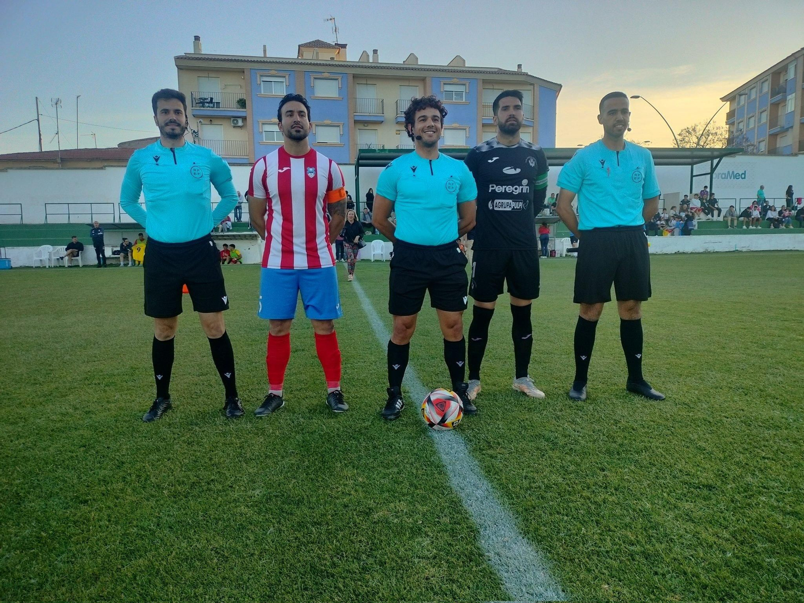 Los capitanes de ambos equipos posan con el trío arbitral antes del comienzo del partido.