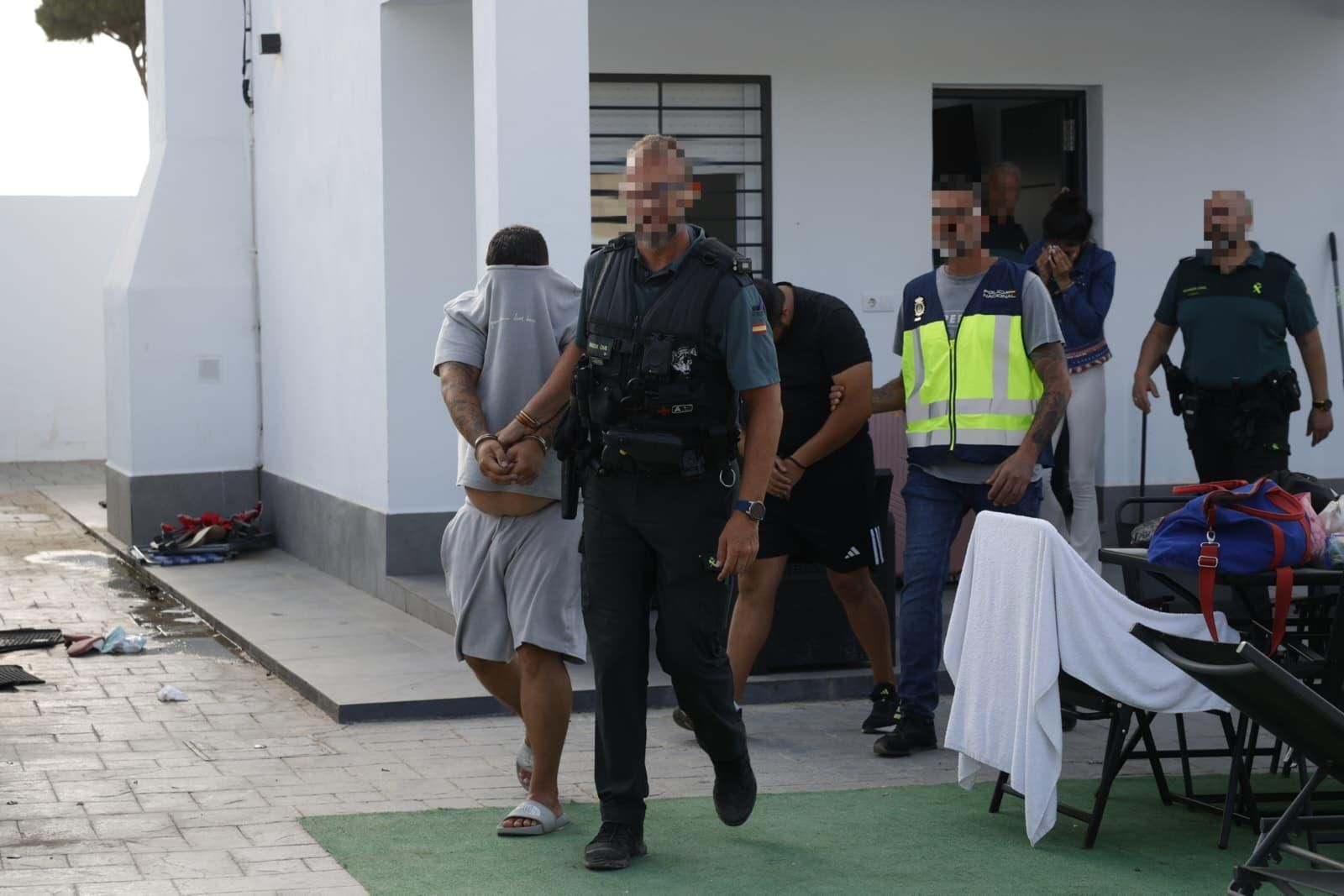 Momentos en el que los efectivos sacan a los detenidos de la vivienda.