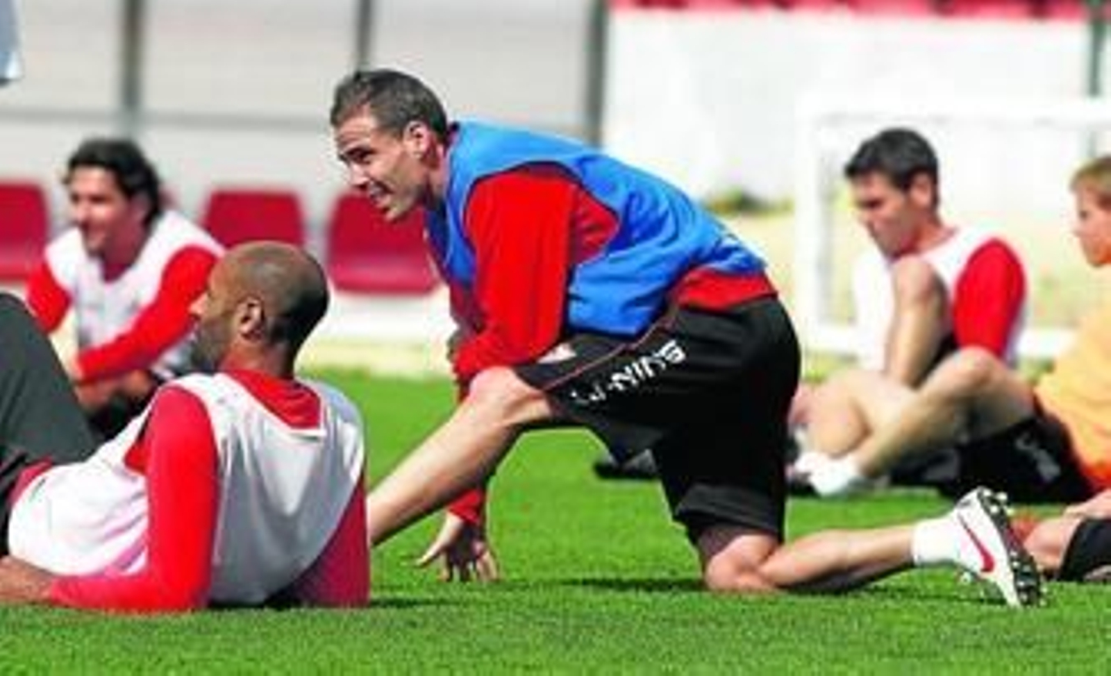 Fernando Navarro, novedad hoy tras cumplir sanción y superar una lesión, hace estiramientos al lado de Kanoute.